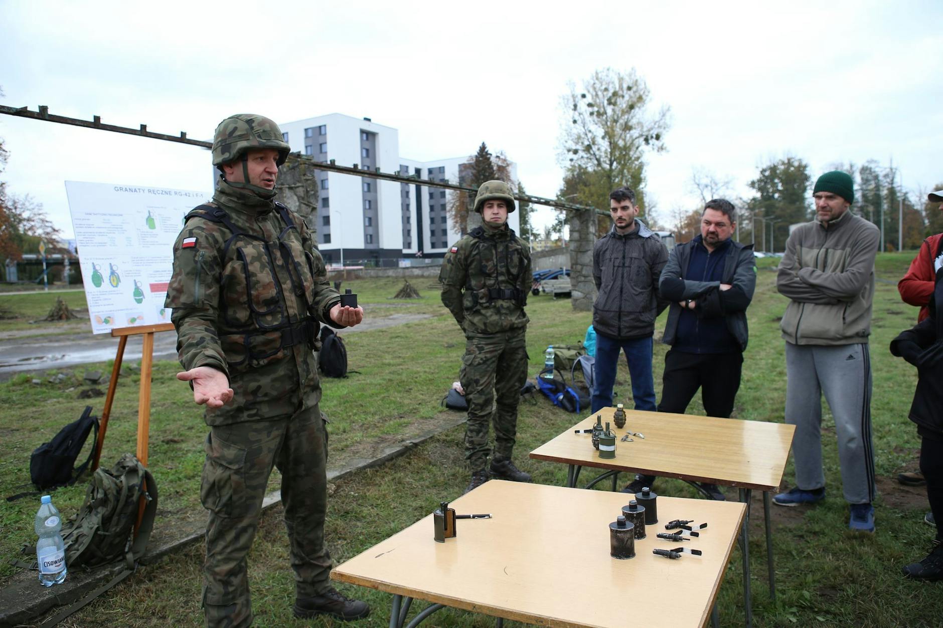 Oberfeldwebel Mariusz Starosz (l.) erklärt auf einem Übungsplatz der polnischen Armee Bürgern den richtigen Umgang mit einer Handgranate.