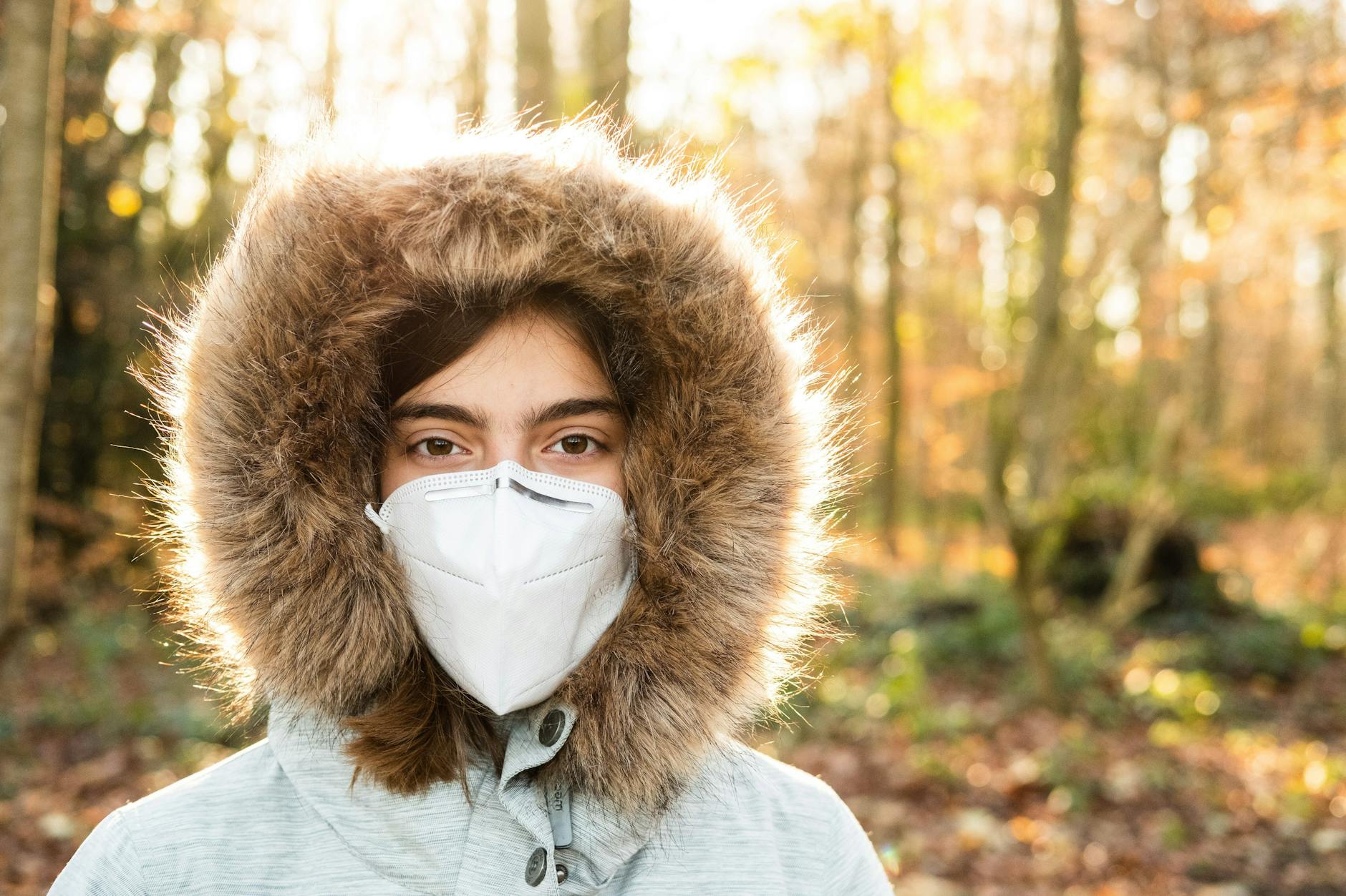 Eine Frau mit FFP2-Maske im Wald.