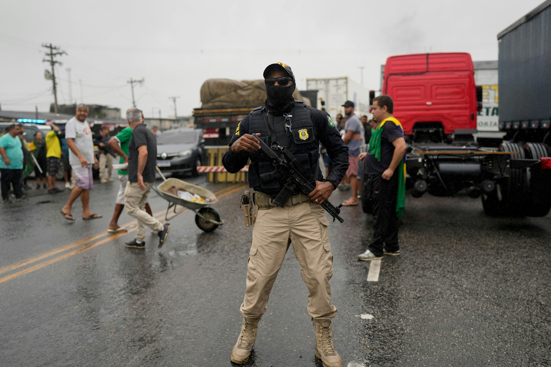 Bundespolizisten beobachten Lastwagenfahrer, die eine Autobahn blockieren, um gegen die Niederlage des ehemaligen brasilianischen Präsidenten Bolsonaro bei der Präsidentschaftswahl zu protestieren.&nbsp;
