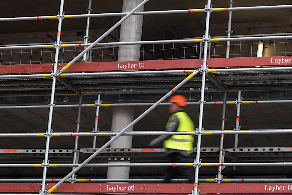ARCHIV - Ein Bauarbeiter geht über eine Baustelle.  