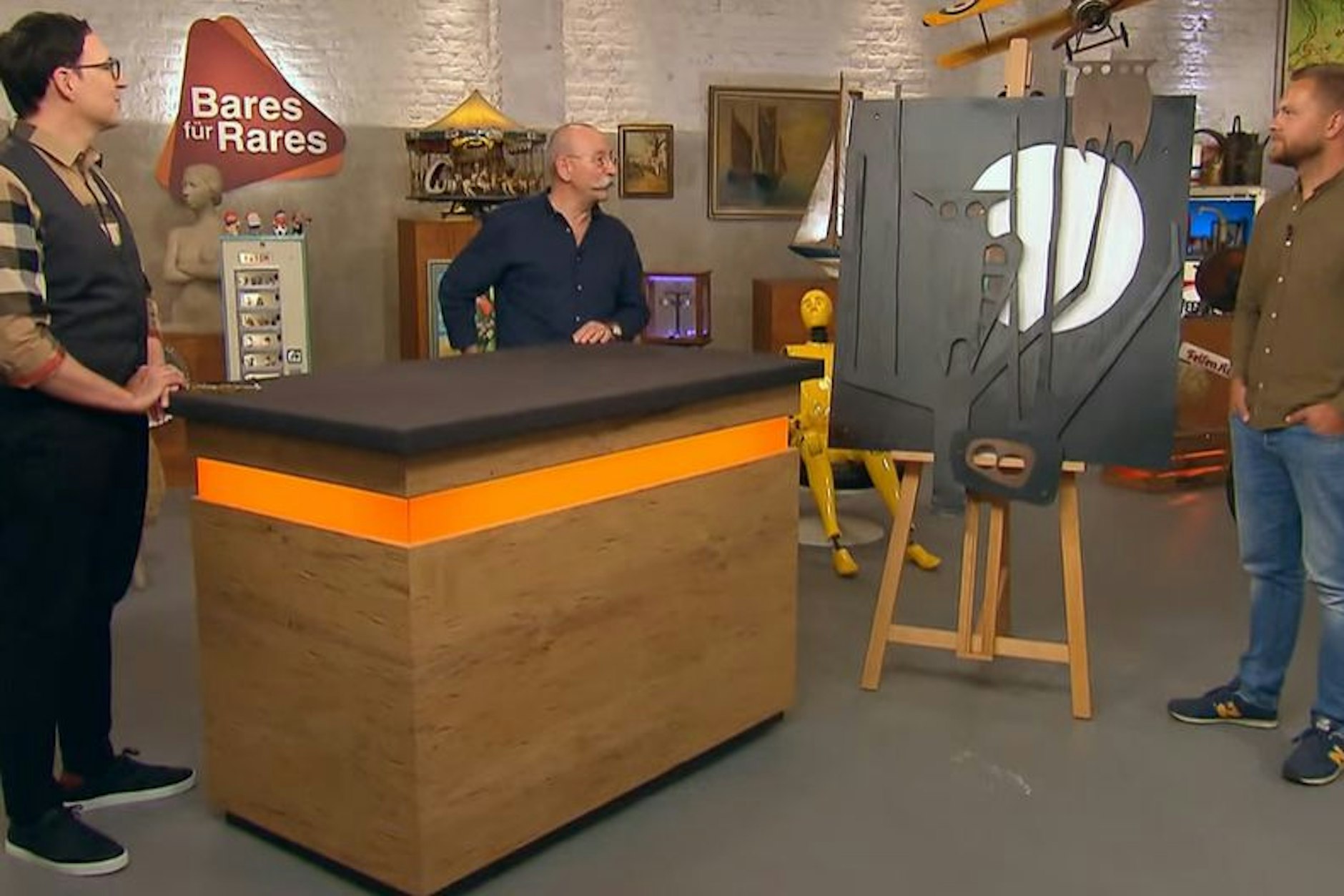 „Bares für Rares“-Experte Colmar Schulte-Goltz (l.) ist begeistert von dem Eisenteil, das „Bares für Rares“-Verkäufer Patrick (r.) da angeschleppt hat.