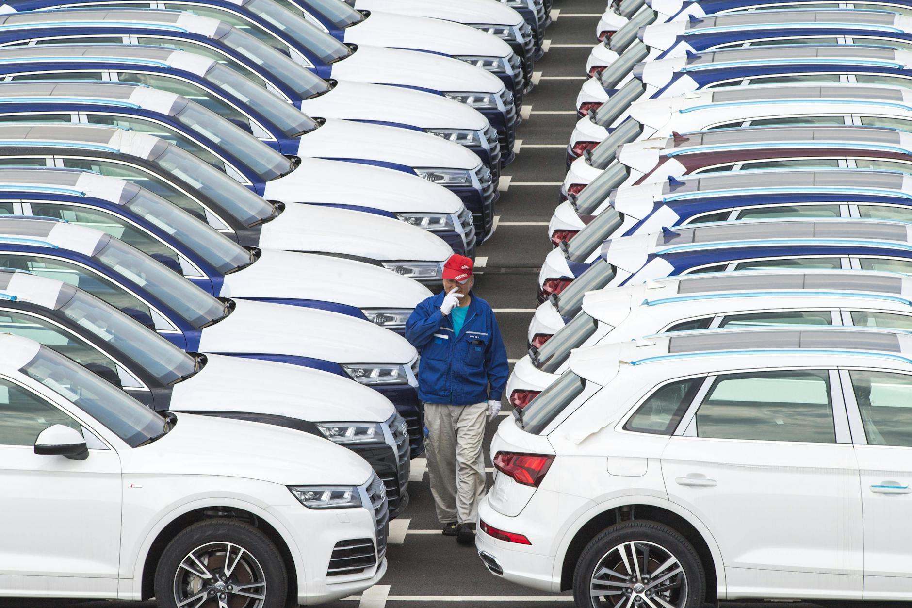 Ein Arbeiter überprüft Audi-Fahrzeuge auf dem Fahrzeugparkplatz von FAW-Volkswagen in Changchun in der nordostchinesischen Provinz Jilin (9. Juli 2019).
