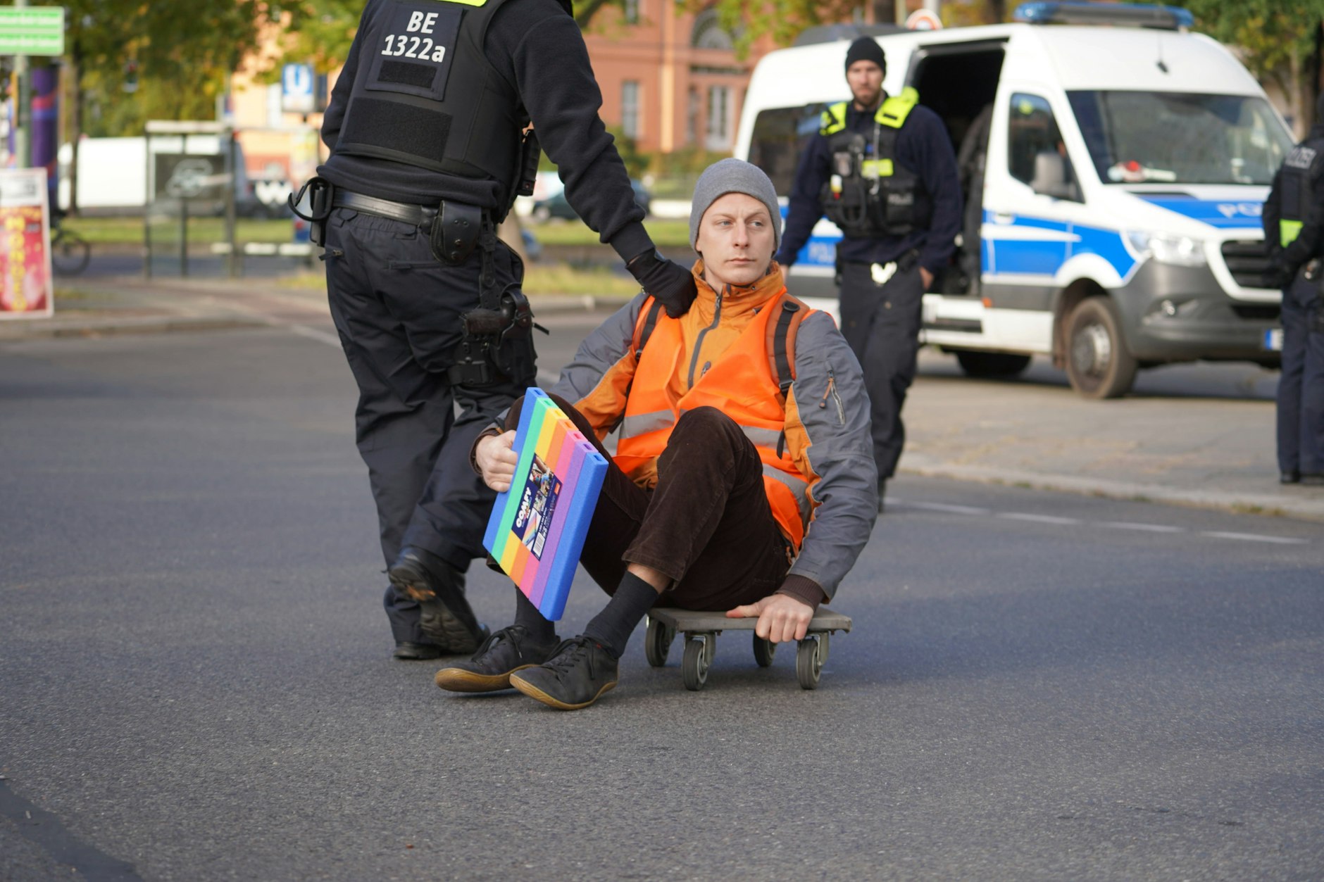 Polizisten nehmen einen Klima-Kleber in Gewahrsam, der die Ausfahrt der Berliner Stadtautobahn A103 in Steglitz blockiert hatte.