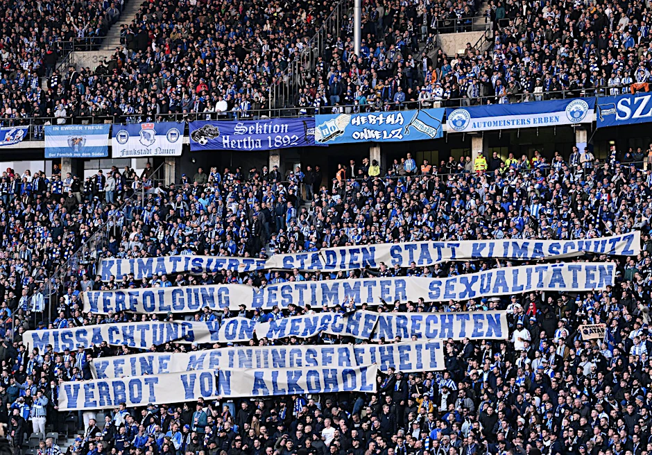 Hertha-Fans in der Ostkurve zeigen Spruchbänder gegen die bevorstehende Fußballweltmeisterschaft in Katar.
