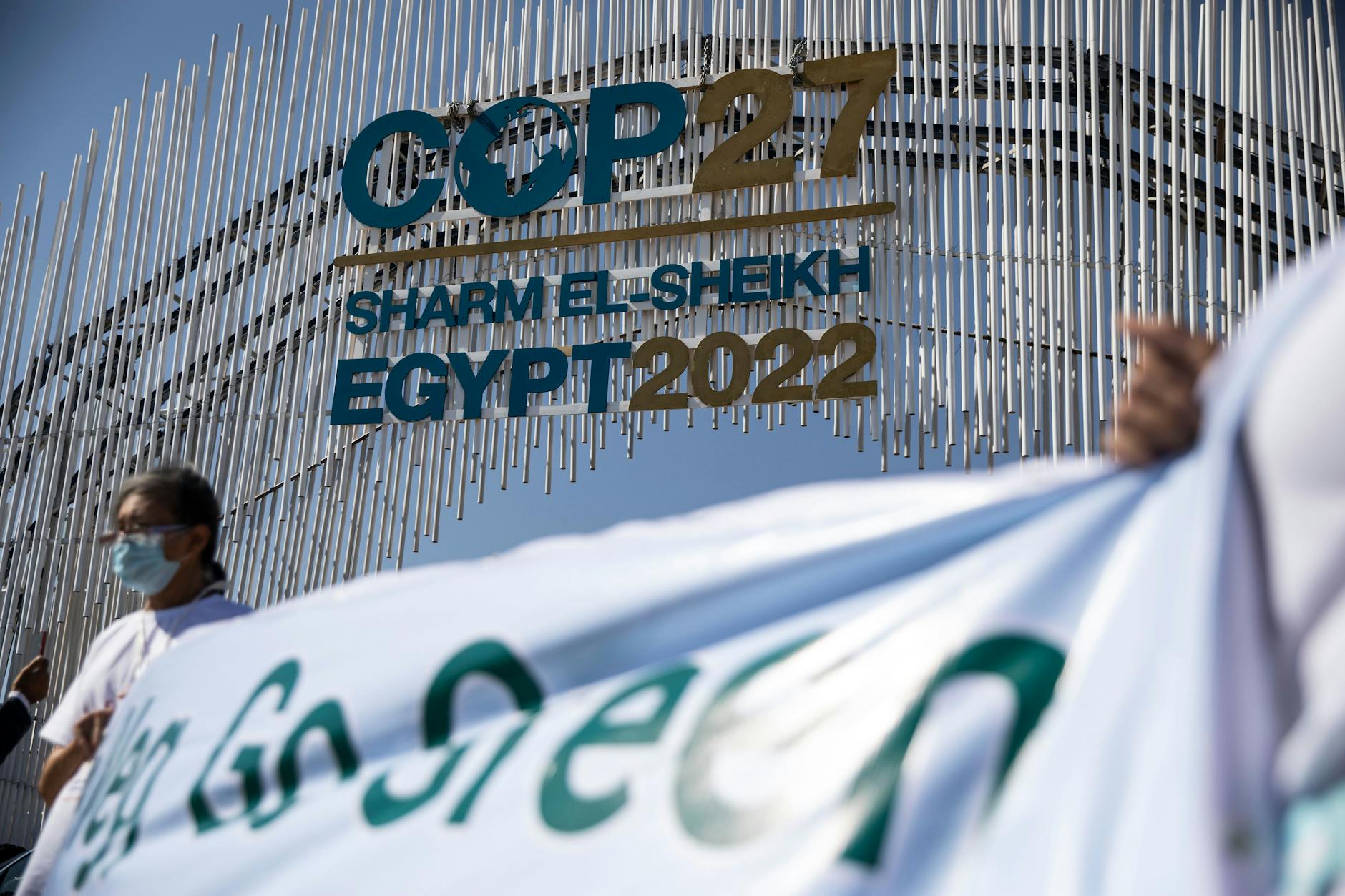Umweltaktivisten halten ein Transparent vor dem Tor zur UN-Klimakonferenz COP27 im International Convention Center in Scharm el-Scheich hoch.