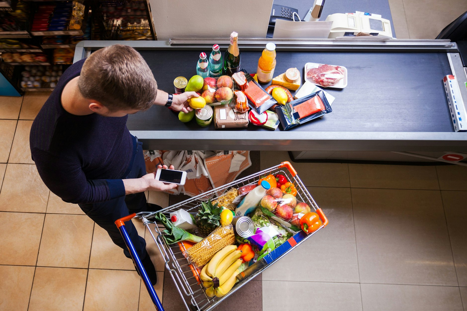 Junger Mann an der Supermarktkasse.