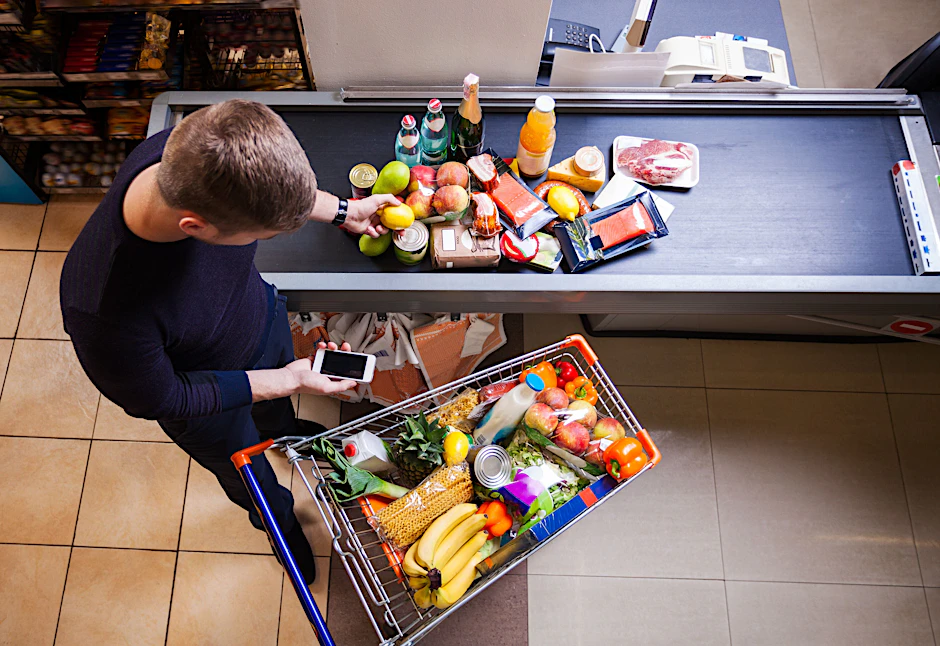 Junger Mann an der Supermarktkasse.