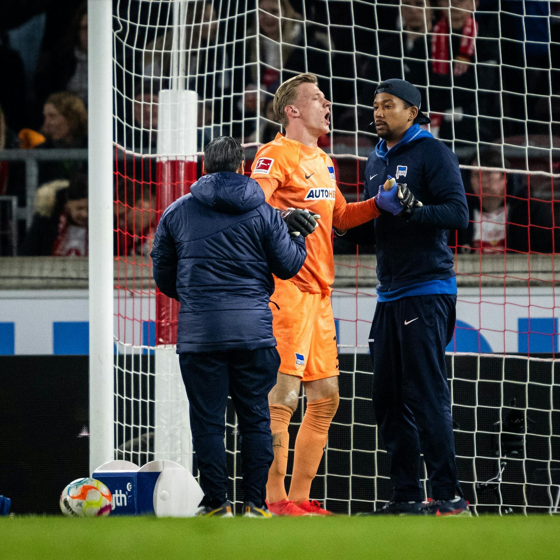 Herthas Torwart Oliver Christensen wird von Teamarzt Hi-Un Park und Physiotherapeut Frederick Syna an der Schulter behandelt.