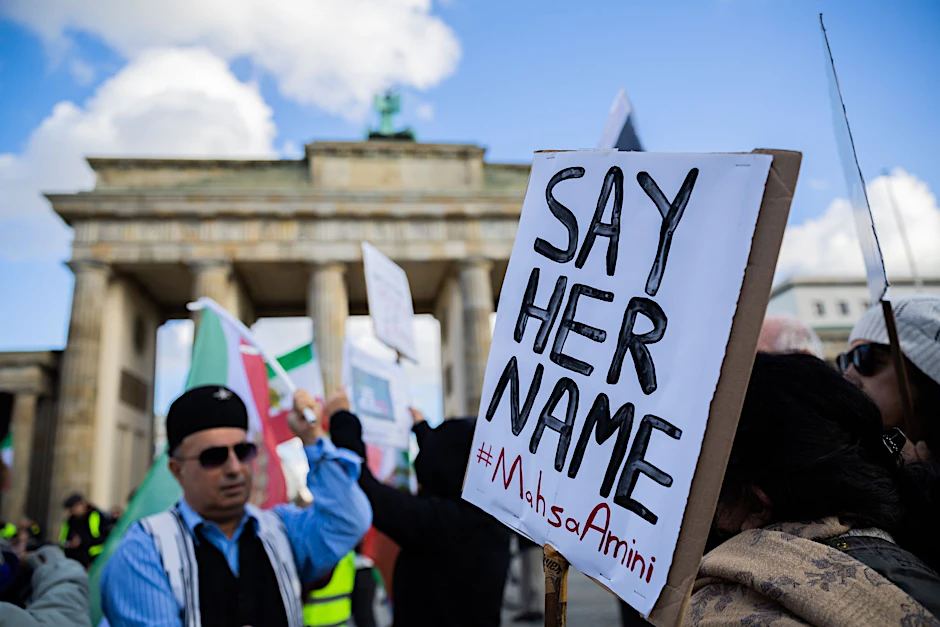 «Say Her Name #Mahsa Amini» steht bei einer Demonstration für Solidarität mit den Protestierenden im Iran am Brandenburger Tor auf einem Schild.  