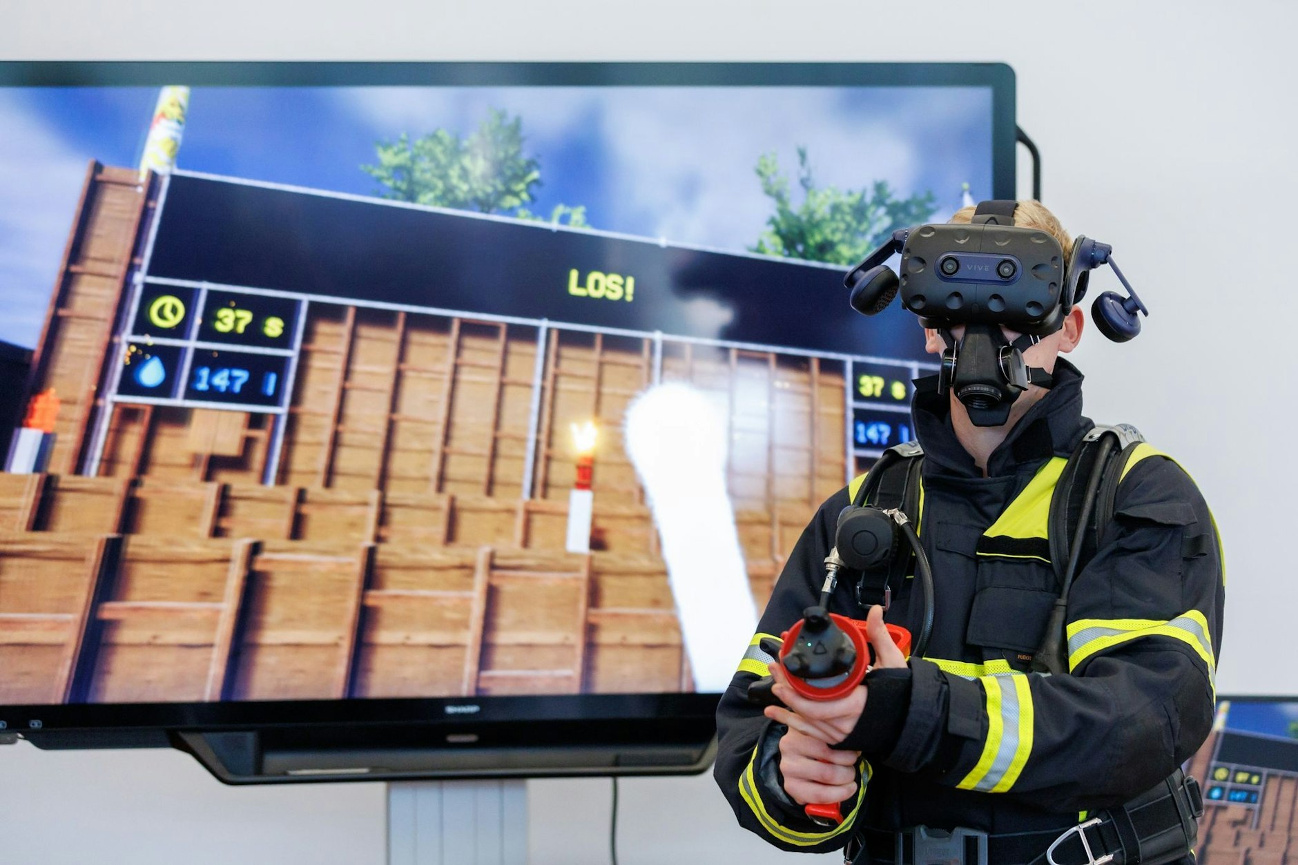dpatopbilder - Alexander Schweigert, Lehrkraft an der staatlichen Feuerwehrschule Würzburg, demonstriert das virtuelle Training zur Innenbrandbekämpfung. Ausgestattet ist er mit einer VR-Brille und einem Hohlstrahlrohr mit VR-Technik.  