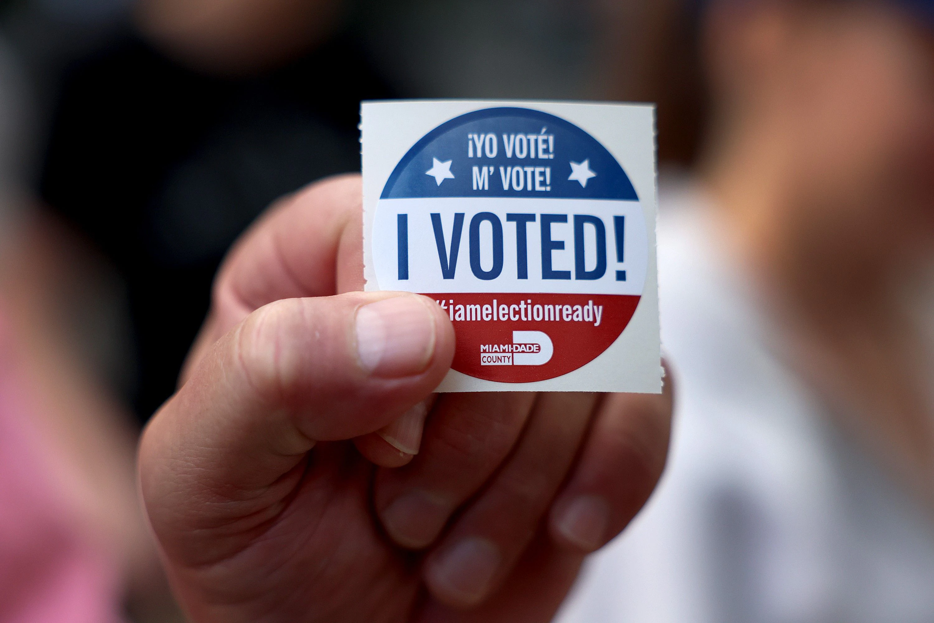 Wähler zeigt seinen „I Voted“-Sticker in die Kamera.