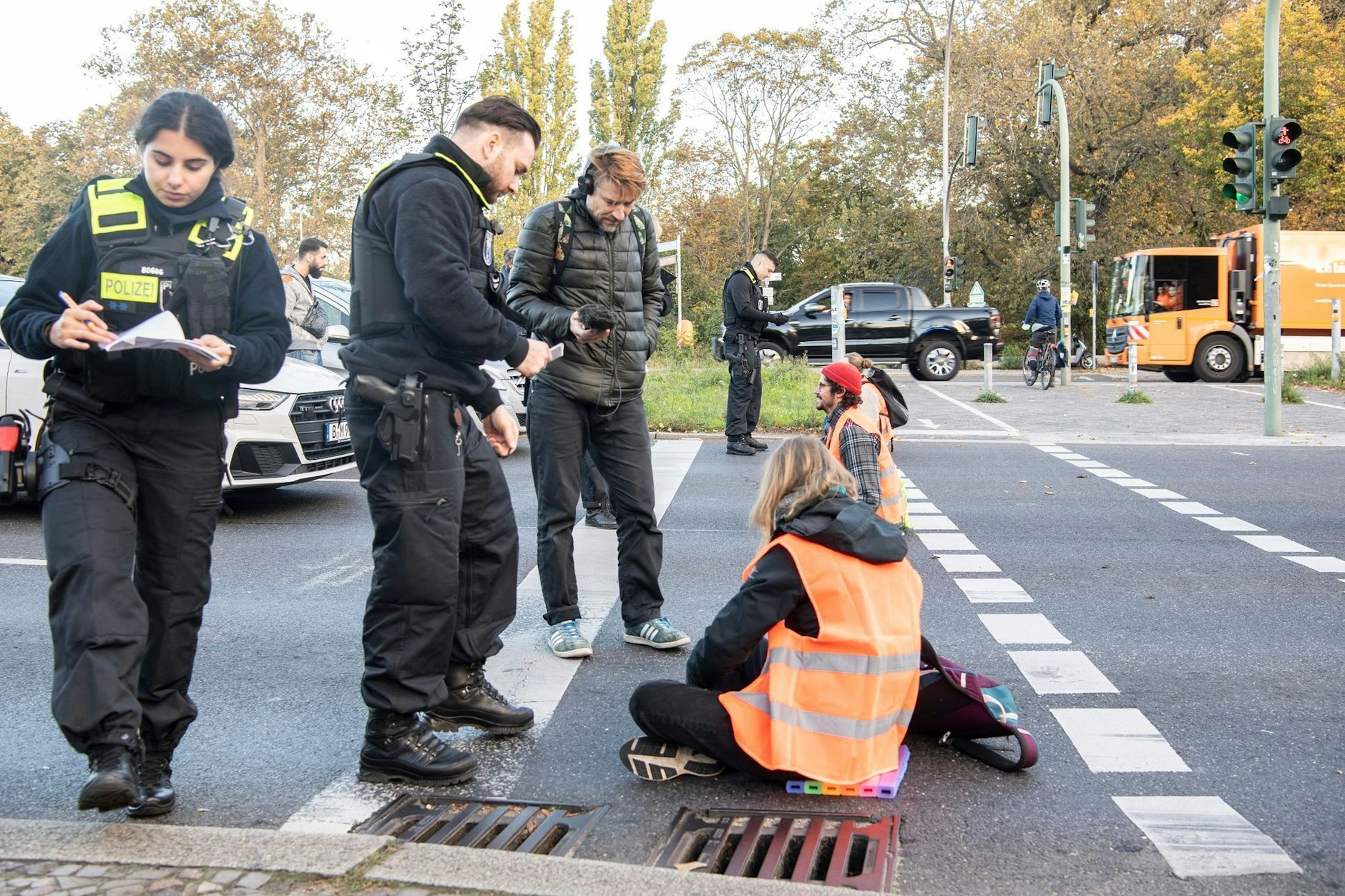 Mitglieder der Gruppe „Letzte Generation“ sitzen bei einer Blockade auf der Seestraße.