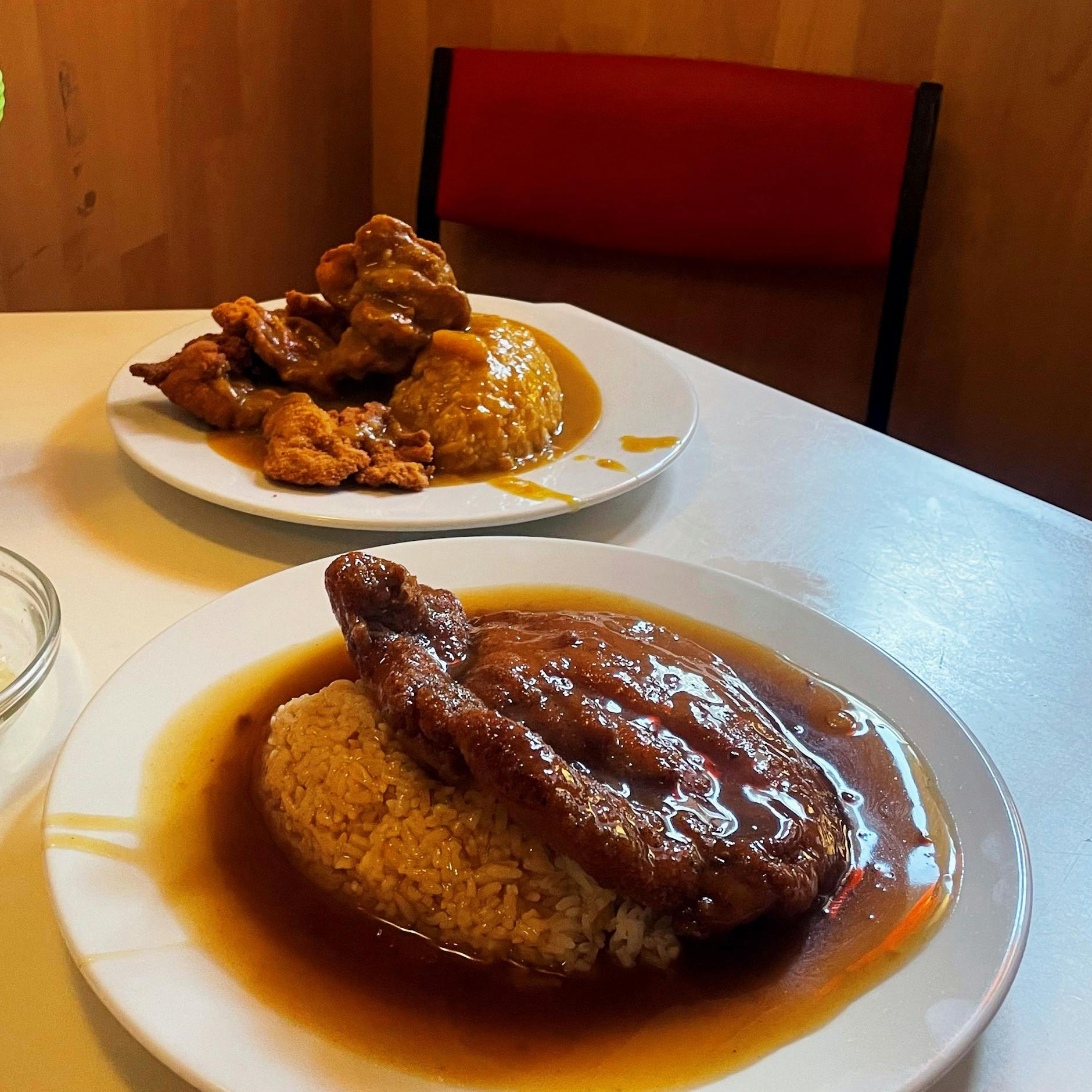 Mächtige Portionen für einen schmalen Taler: Vorne das Schnitzel mit Bratensoße, hinten kleine Hähnchen-Nuggets mit Currysoße.