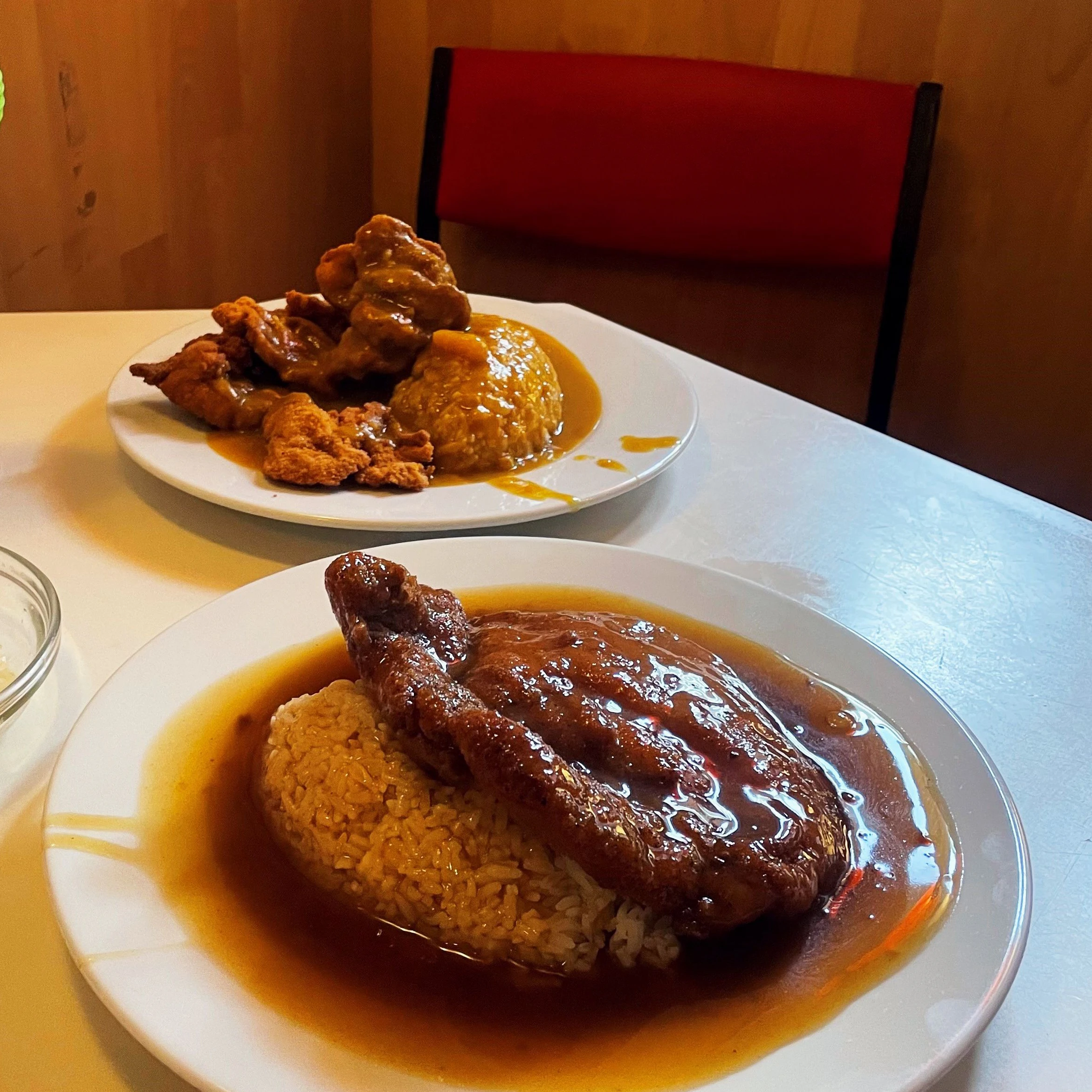 Mächtige Portionen für einen schmalen Taler: Vorne das Schnitzel mit Bratensoße, hinten kleine Hähnchen-Nuggets mit Currysoße.