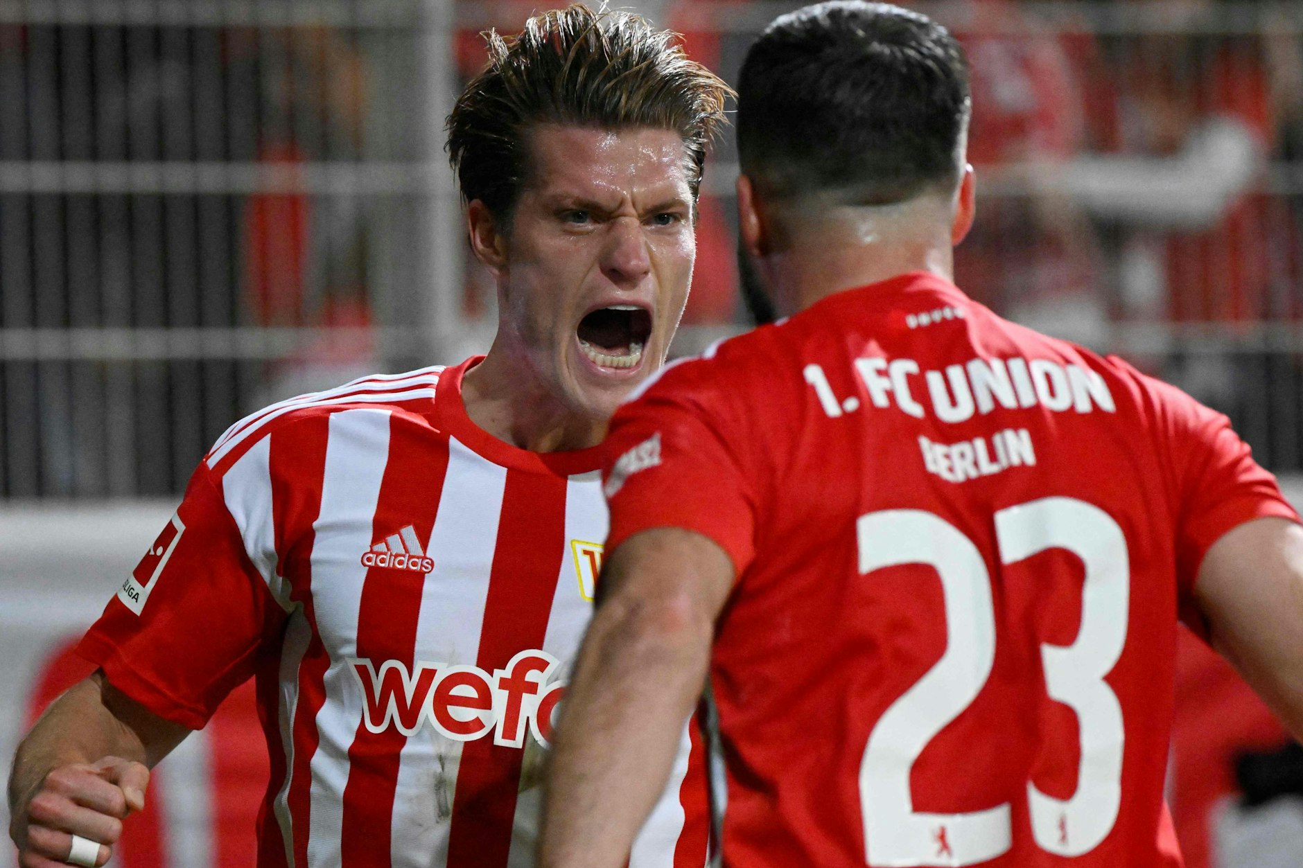 Kevin Behrens schreit nach seinem Treffer zum 2:1 vor Freude und läuft auf Vorarbeiter Niko Gießelmann zu.