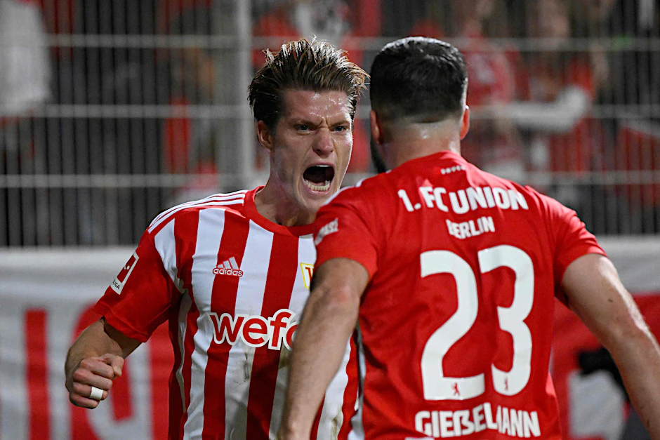 Kevin Behrens schreit nach seinem Treffer zum 2:1 vor Freude und läuft auf Vorarbeiter Niko Gießelmann zu.
