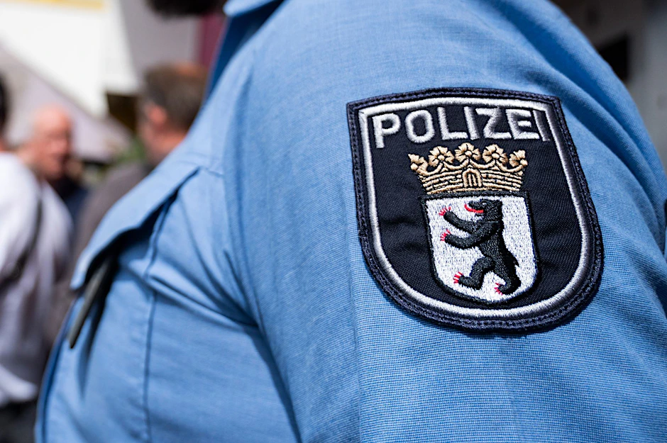 Ein Polizist der Berliner Polizei steht auf der Straße.