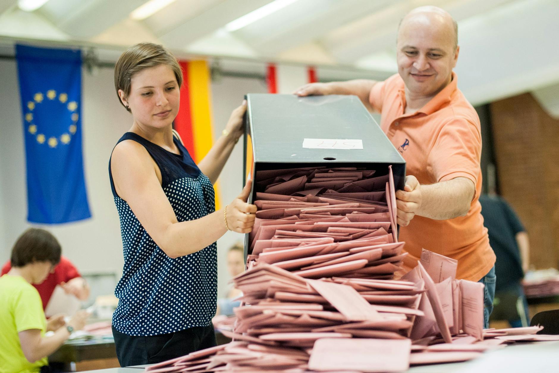 Wahlhelfer leeren eine Wahlurne mit Briefwahlstimmen in der Mensa einer Schule in Berlin. Bei der Europawahl dürfen nun auch Jugendliche ab 16 Jahren ihre Stimme abgeben. 