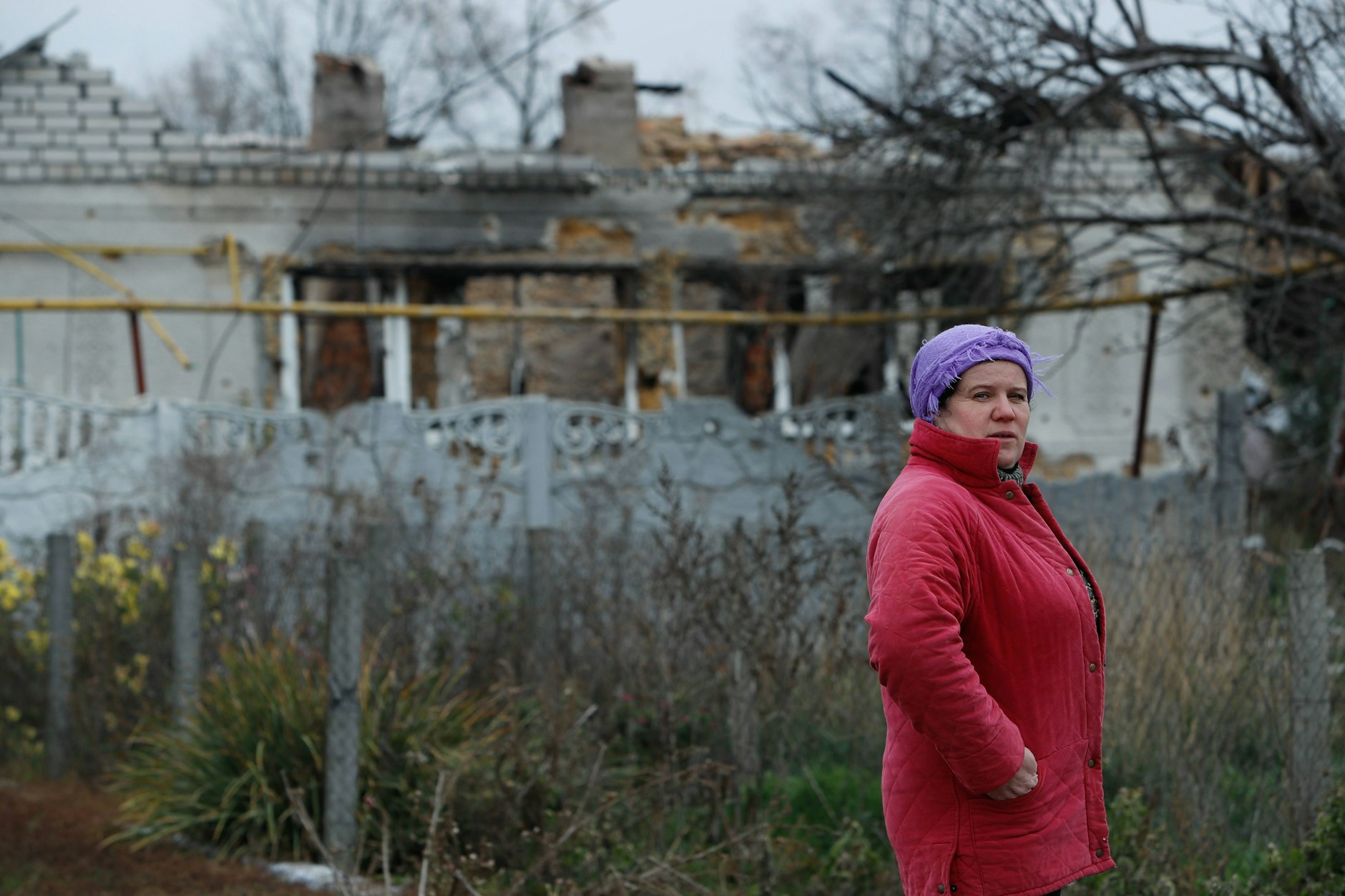 Eine Frau vor ihrem zerstörten Wohnhaus nahe der Stadt Cherson