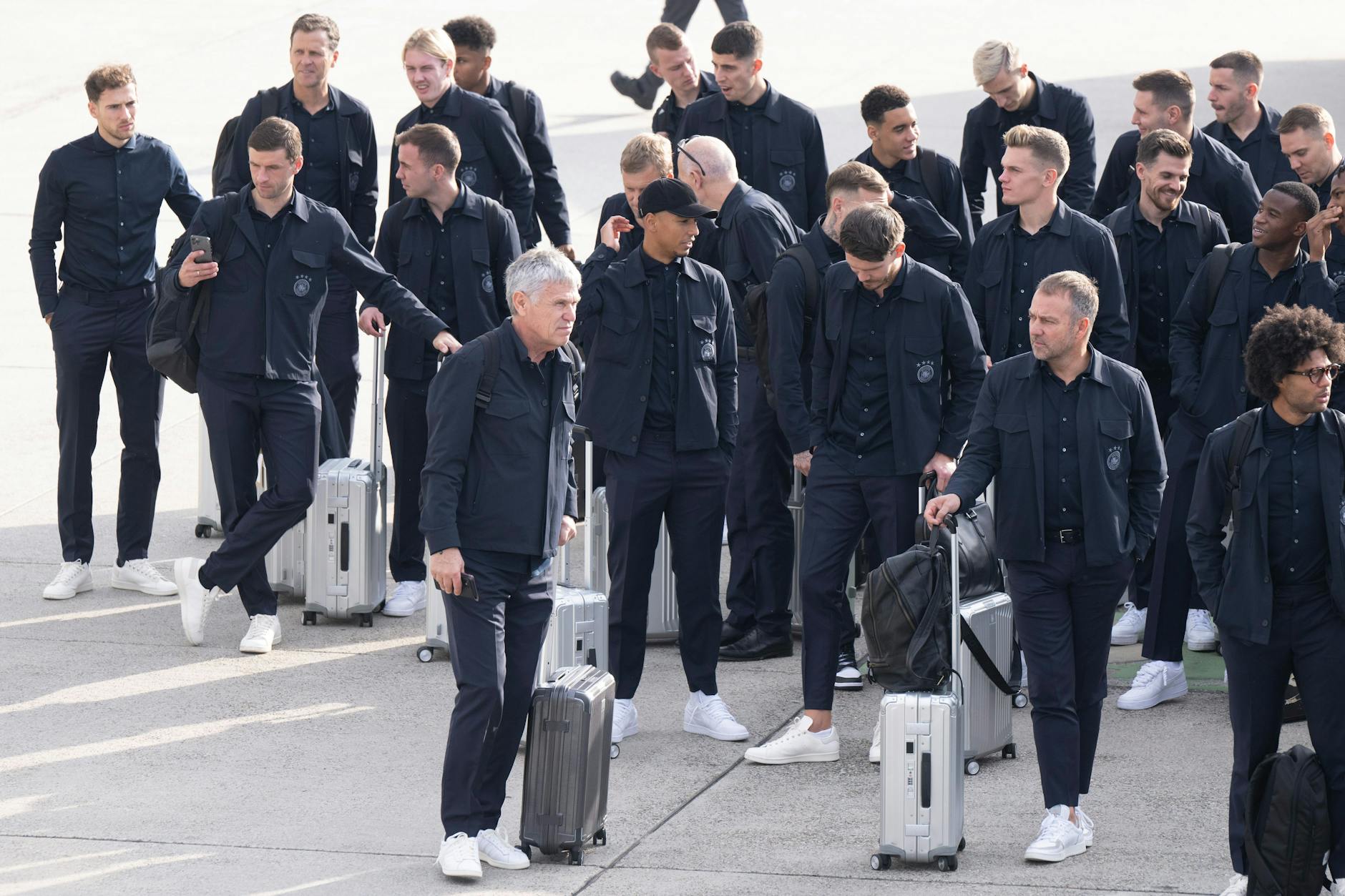 Bundestrainer Hansi Flick (2. v. r.) wartet mit der Nationalelf auf dem Rollfeld am Flughafen Frankfurt. Alle sind bereit für den Abflug zur WM. 