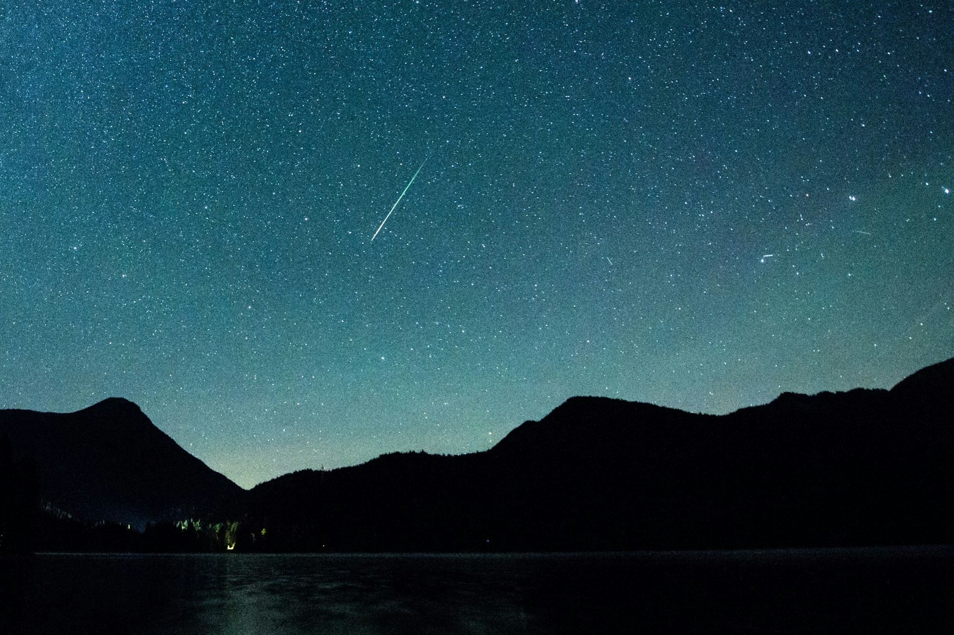 Eine Sternschnuppe leuchtet am Himmel.
