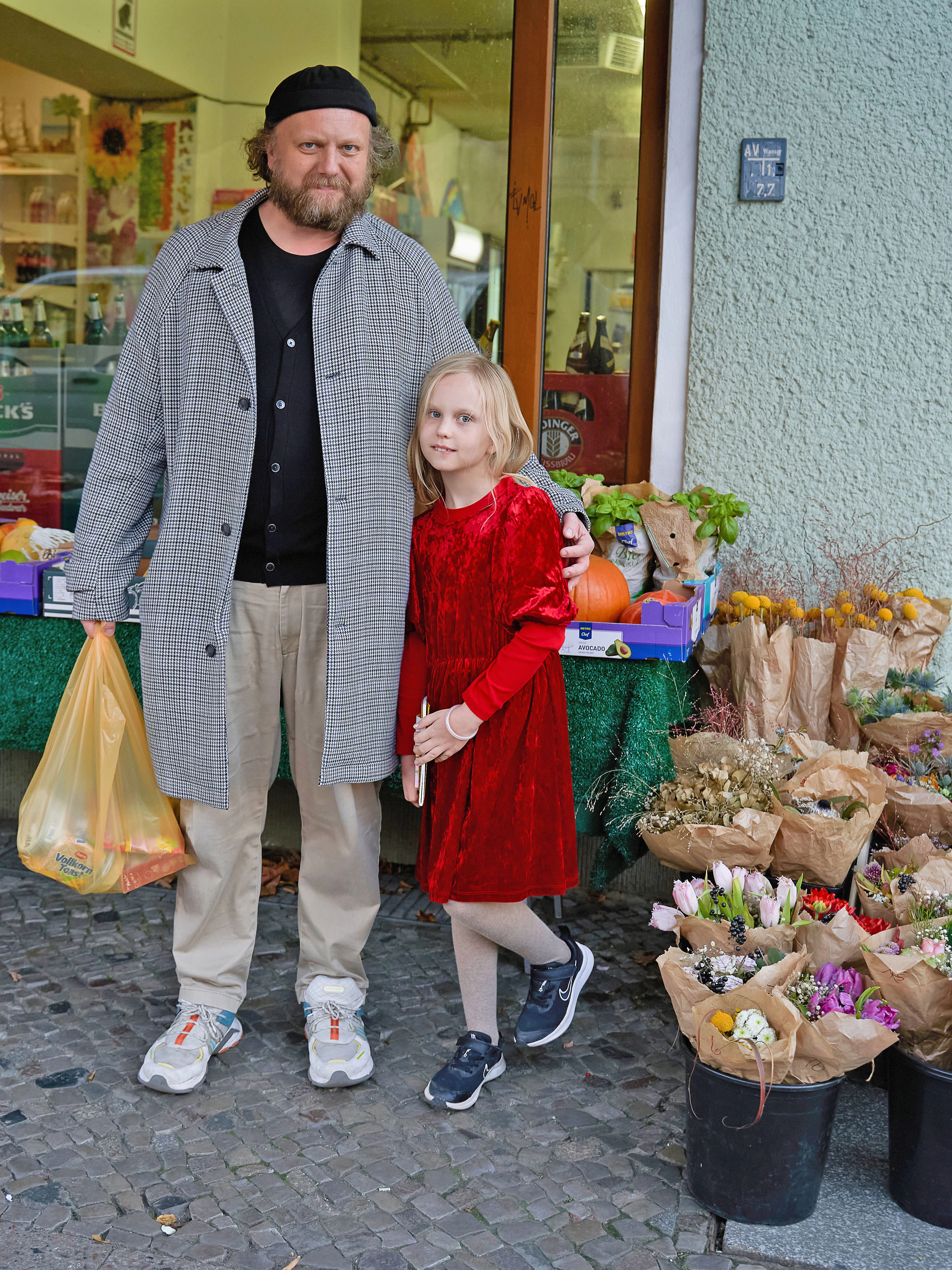 Nicolas und Töchterchen Matilda erledigen gerade ein paar Einkäufe im Kiez. Nicolas ist Kulturunternehmer und hat die Stadt schon als „Prince Charles“-Clubbetreiber mitgeprägt. Er trägt einen leichten Hahnentritt-Mantel von Boss, dazu einen Cardigan und eine Hose von Uniqlo. Matilda wollte heute ihr „Weihnachtskleid“ tragen, der Vater hatte nichts dagegen.