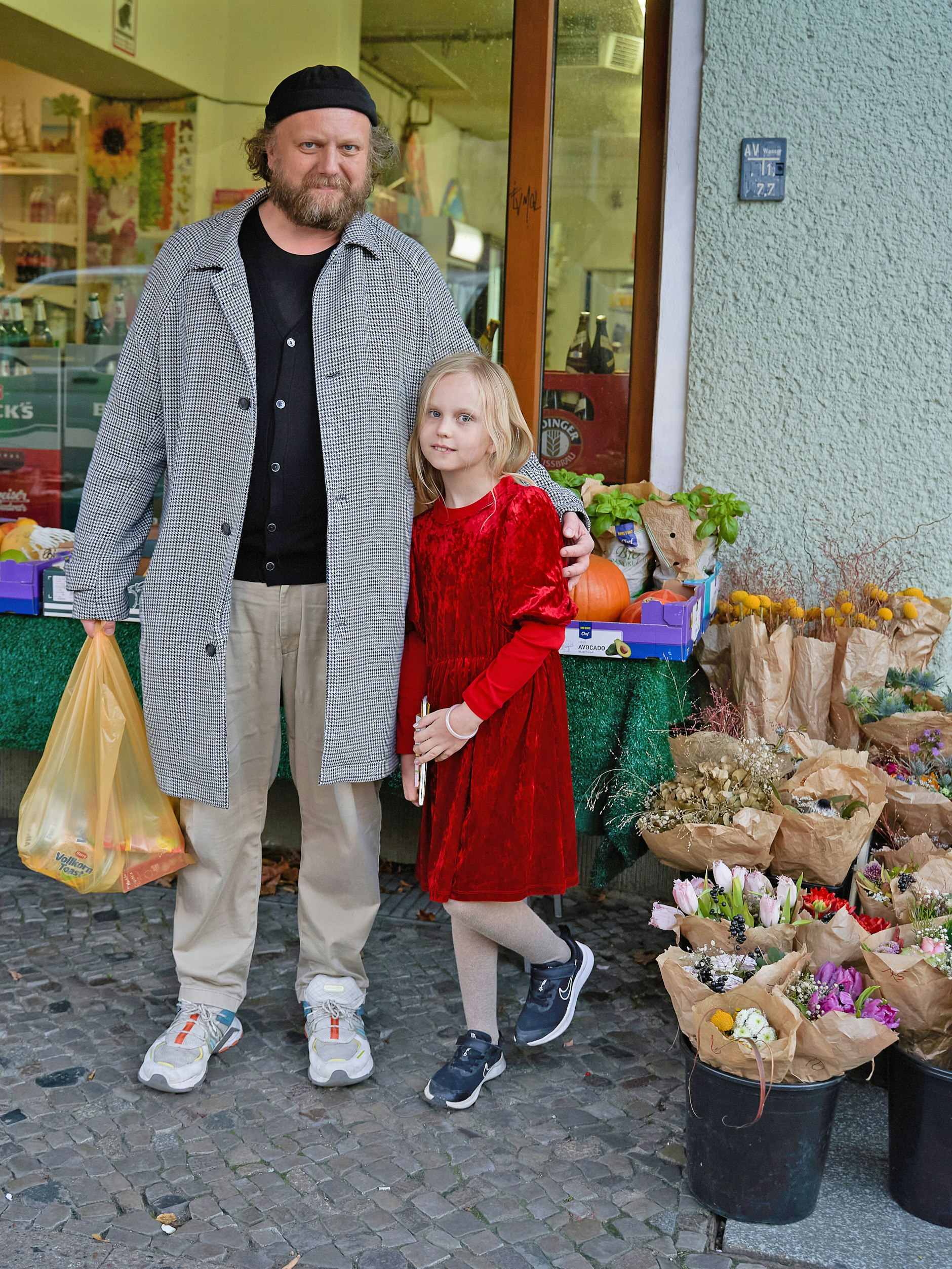 Nicolas und Töchterchen Matilda erledigen gerade ein paar Einkäufe im Kiez. Nicolas ist Kulturunternehmer und hat die Stadt schon als „Prince Charles“-Clubbetreiber mitgeprägt. Er trägt einen leichten Hahnentritt-Mantel von Boss, dazu einen Cardigan und eine Hose von Uniqlo. Matilda wollte heute ihr „Weihnachtskleid“ tragen, der Vater hatte nichts dagegen.