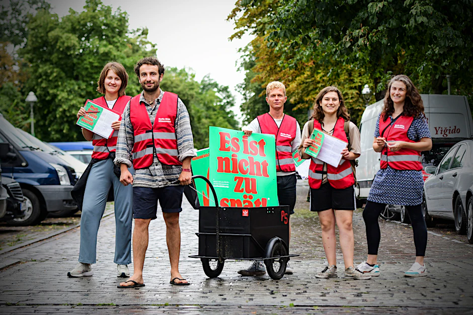 Gruppenbild mit Anhänger: Fünf Leute sammeln im Sommer in Berlin Unterschriften.