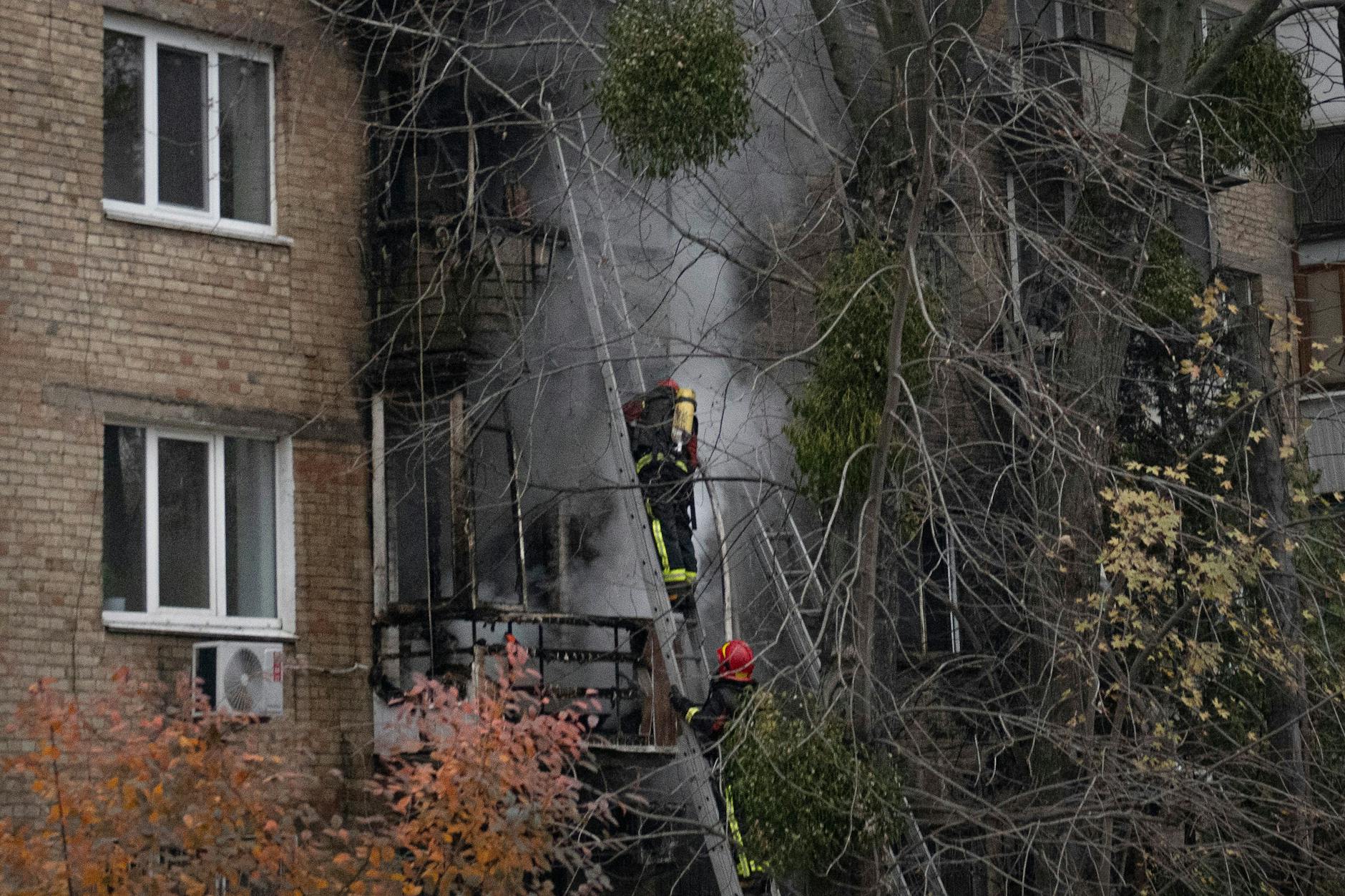 Feuerwehrleute löschen ein Feuer, das durch einen Raketentreffer in einem Wohnhaus entstanden war.