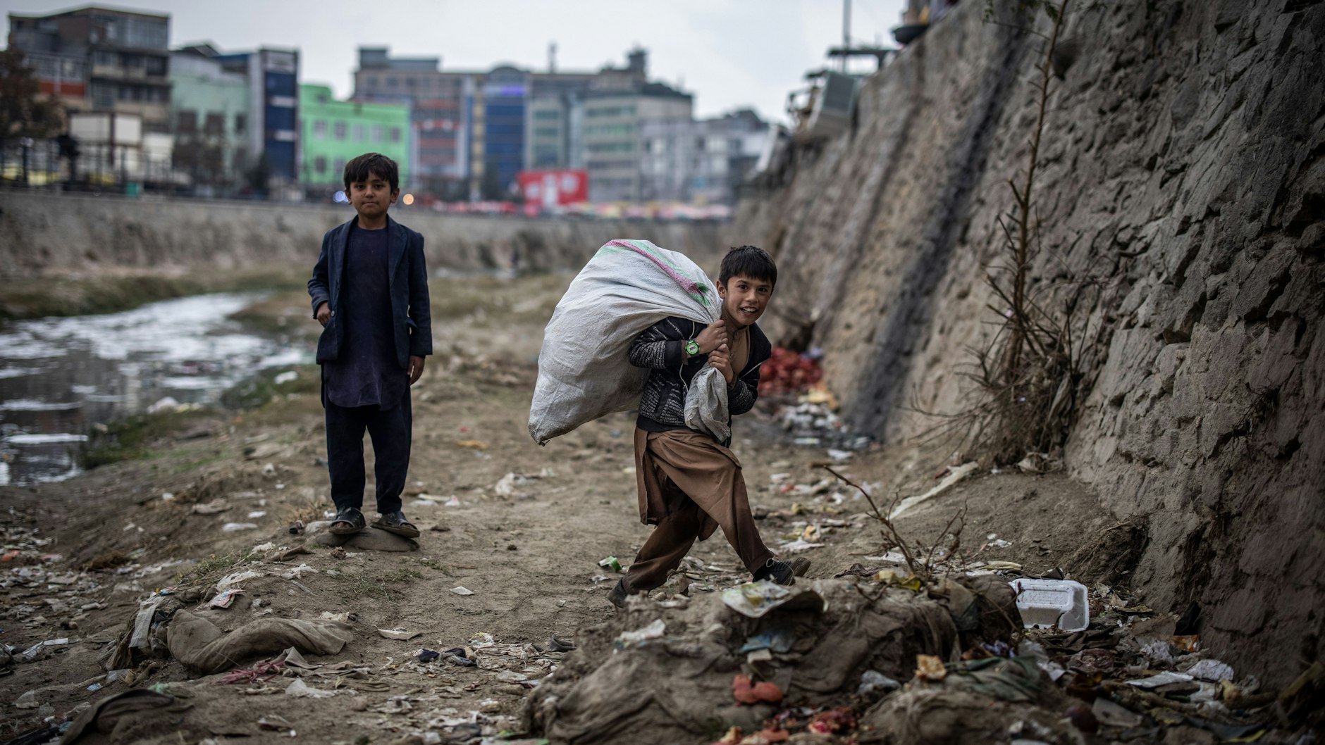 Kabul: Zwei Jungen suchen am Ufer des Kabul-Flusses nach Plastikflaschen, die sie für wenig Geld an ein Recyclingzentrum verkaufen können. Viele Kinder in Afghanistan müssen arbeiten, um zum Familieneinkommen beizutragen.&nbsp;