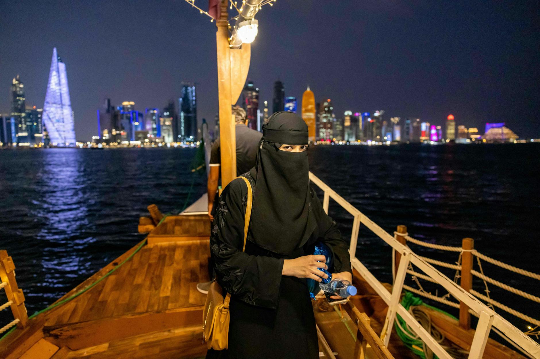 Eine Frau auf einer traditionellen Dhau entlang der Bucht in Doha, kurz vor der WM 2022.