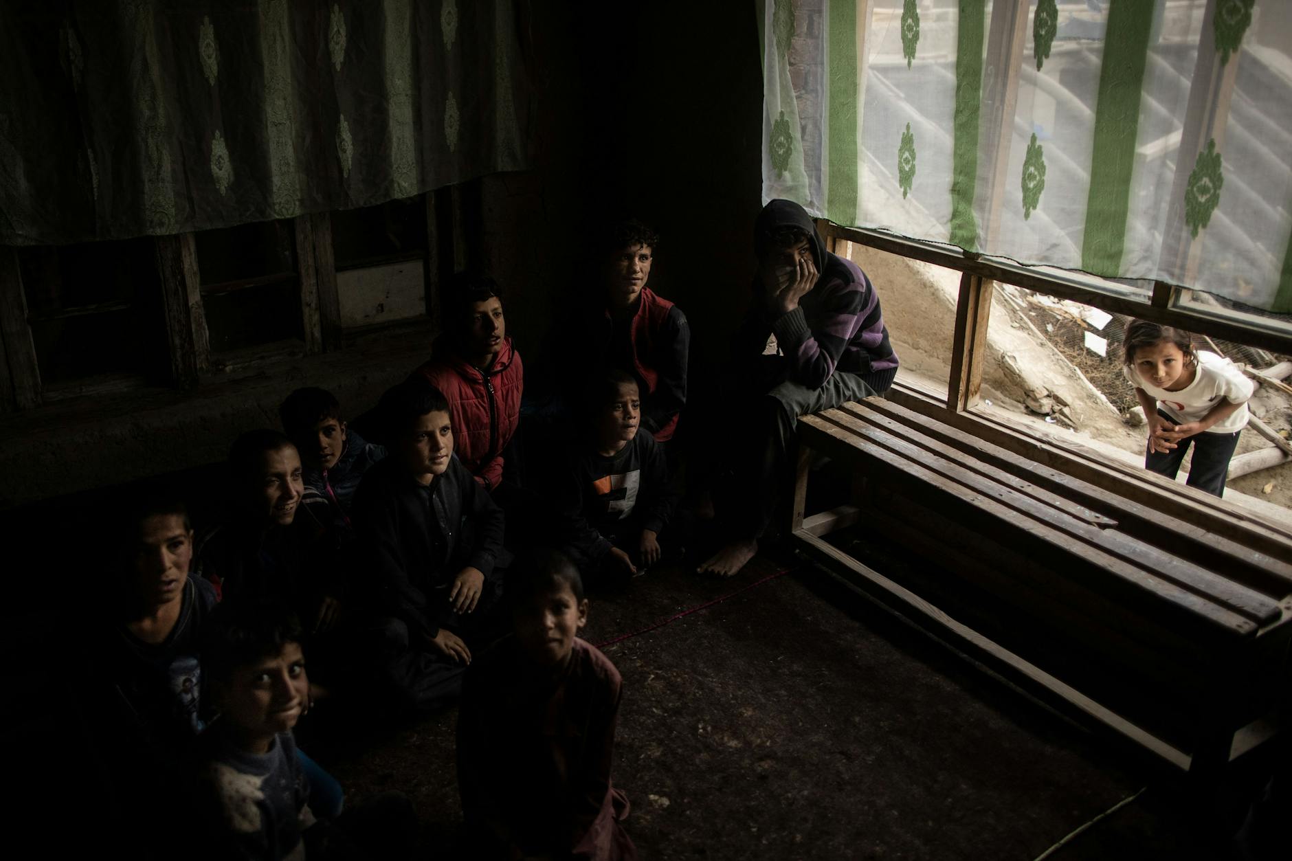 Ein junges Mädchen späht in das Klassenzimmer, in dem der 8-jährige Mortasa mit anderen Jungen sitzt. 