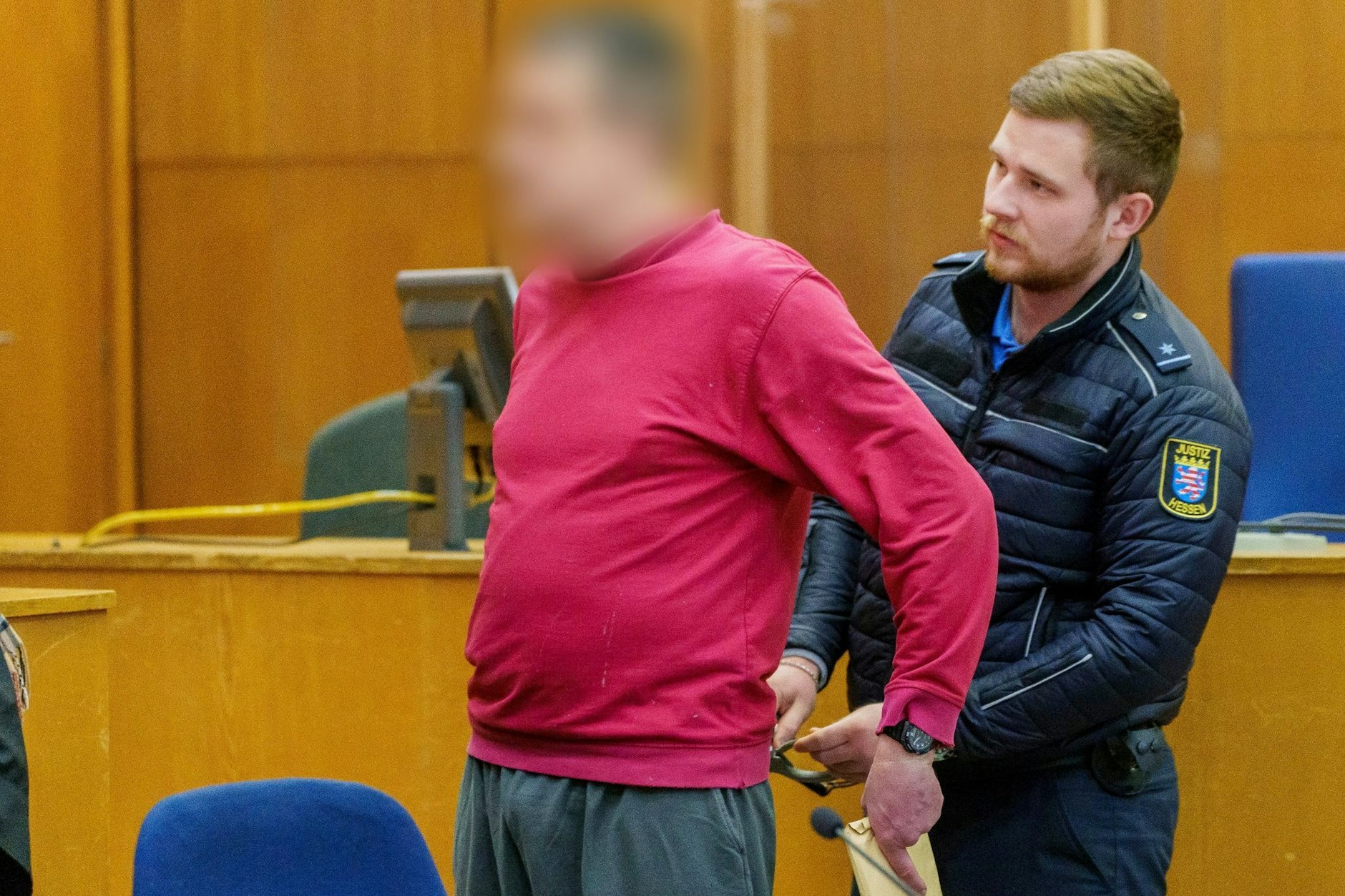 Vor Beginn der Gerichtssitzung, bei der Alexander M. verurteilt wurde, nimmt ihm ein Justizwachtmeister die Handschellen ab.