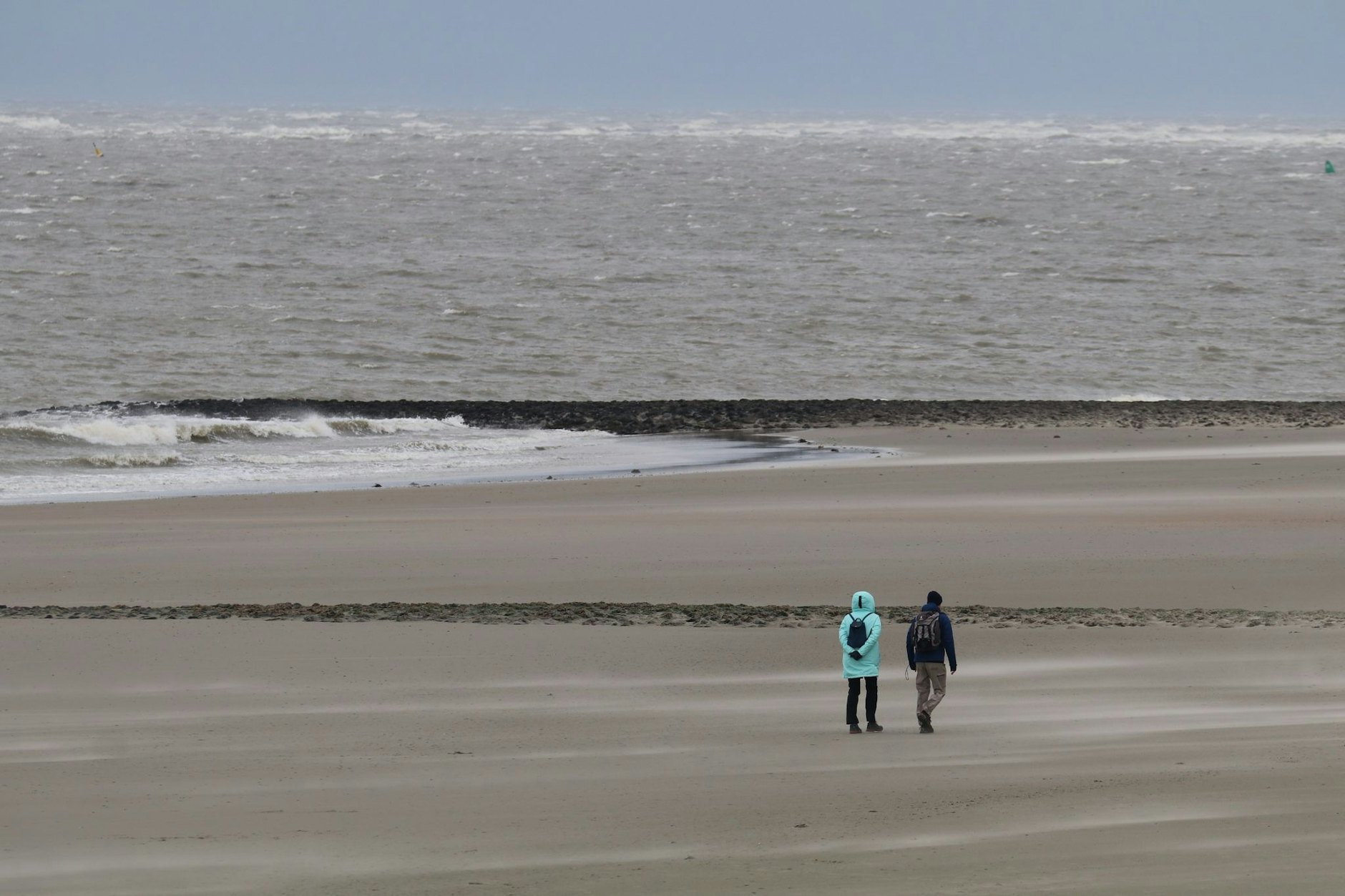 Auf der osttfriesischen Insel Norderney genießen hartgesottene Spaziergänger trotz des stürmischen Wetters die Weitsicht auf das Meer.  