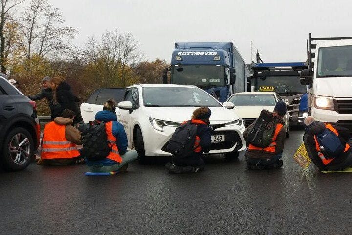 Aktivisten parkten Autos quer und klebten sich an der Straße fest. An der Zufahrt zum BER auf der A113 gibt es Stau.