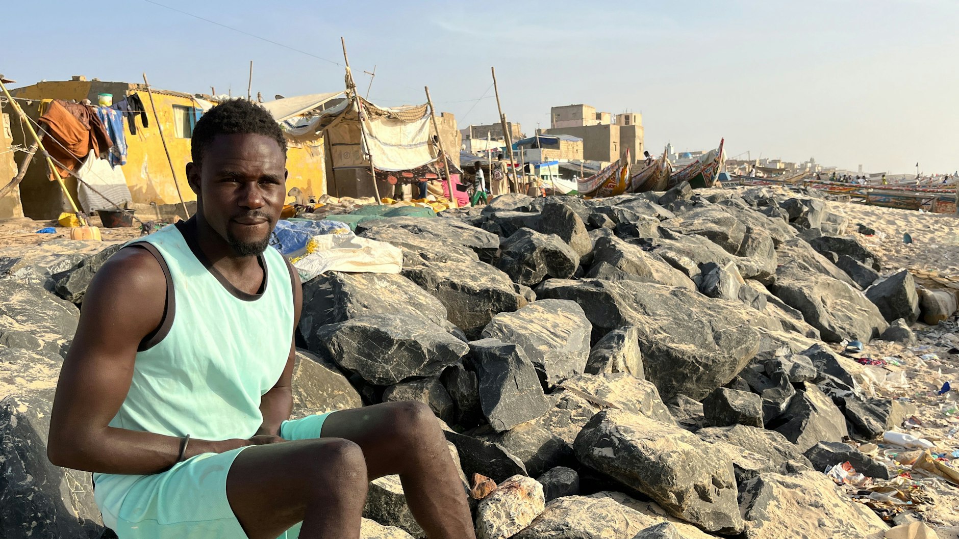 Der Fischer Bamba Diop sitzt auf dem Damm, der St. Louis vor dem Atlantik schützen soll.