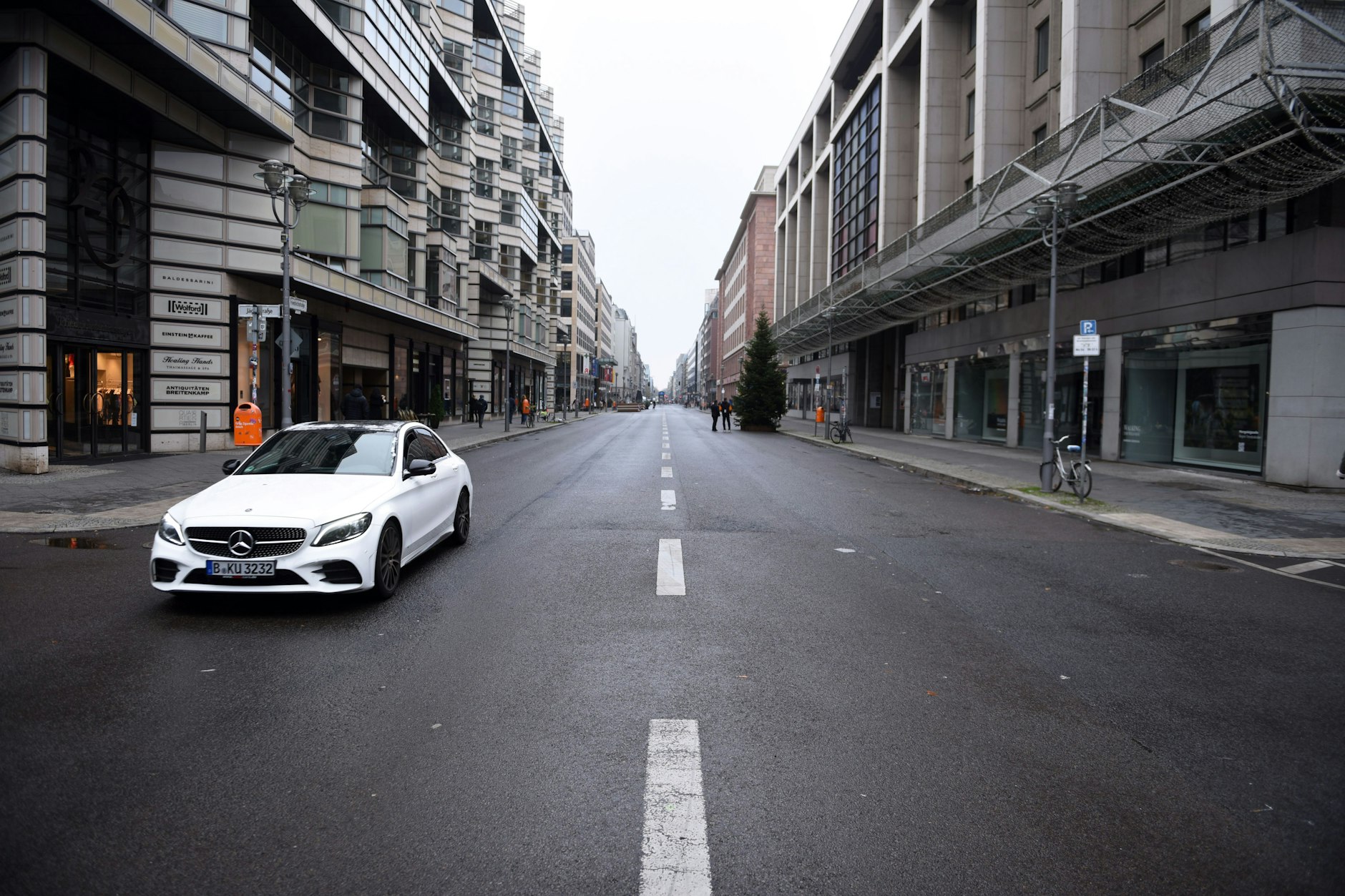 Die Friedrichstraße in Mitte. Bis vor kurzem standen Sitzgelegenheiten und Blumenkübel auf der Fahrbahn. In der Nacht zu Mittwoch muss der Abschnitt rund um die Galeries Lafayette wieder für Kraftfahrzeuge geöffnet werden, vorübergehend. Obwohl das Verbot am Montag noch galt, waren dort schon wieder Autos unterwegs.