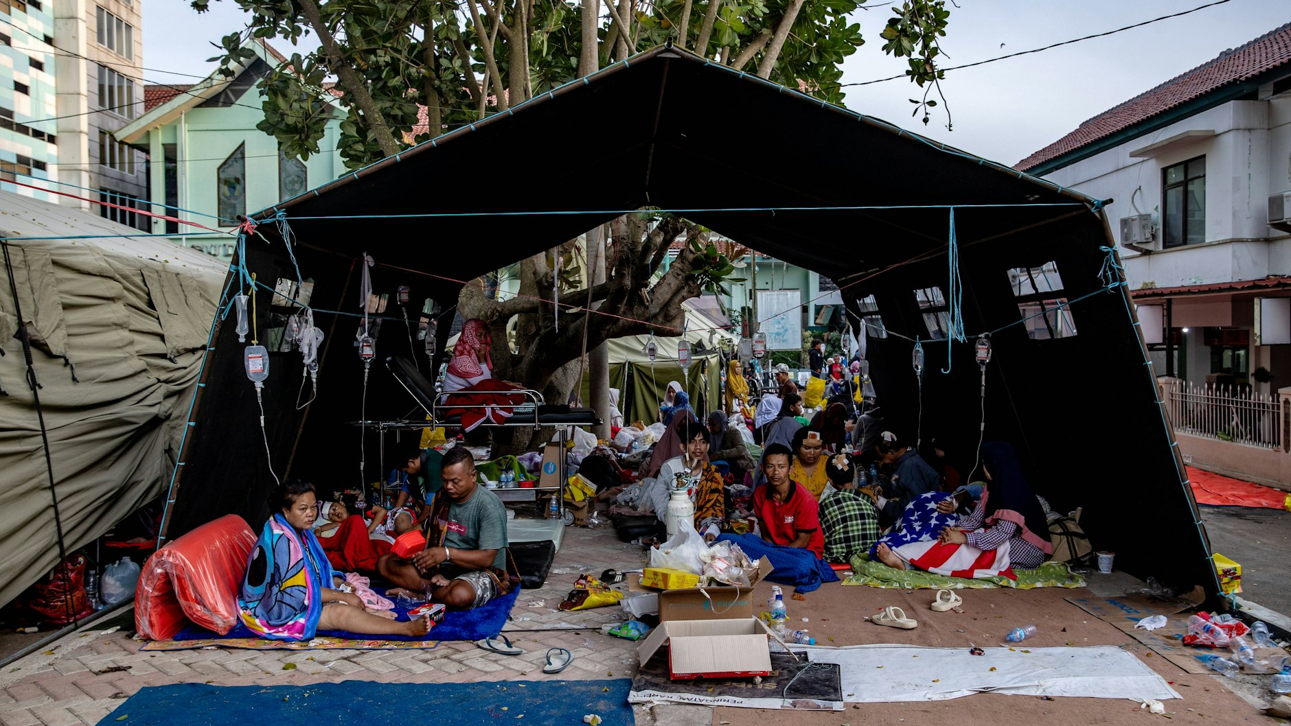 Indonesien: Menschen suchen außerhalb von Gebäuden Schutz unter einem Zelt.&nbsp;