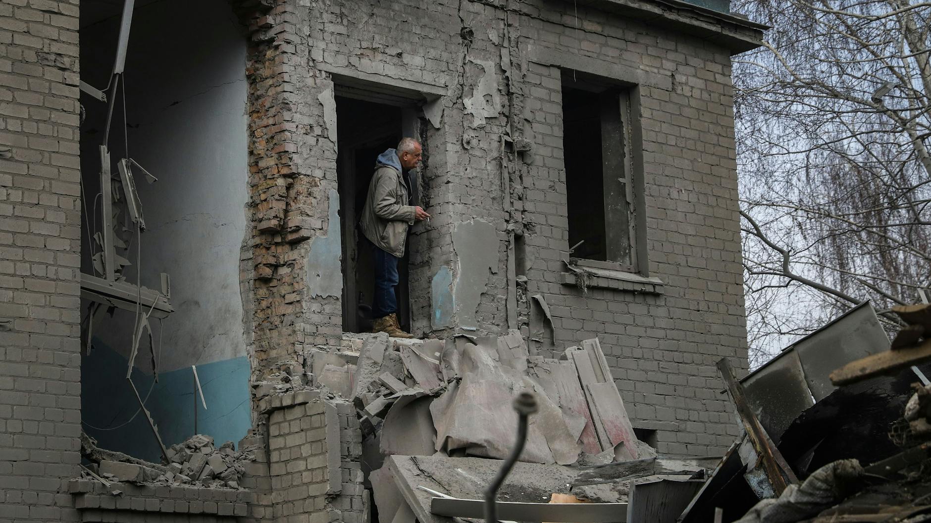 In Wilniansk blickt ein Mann aus der beschädigten Entbindungsstation eines Krankenhauses. Bei neuen russischen Raketenangriffen auf Kiew und weitere Gebiete sind nach Angaben der Ukraine mehrere Menschen getötet worden, darunter ein Säugling in einem Krankenhaus. 