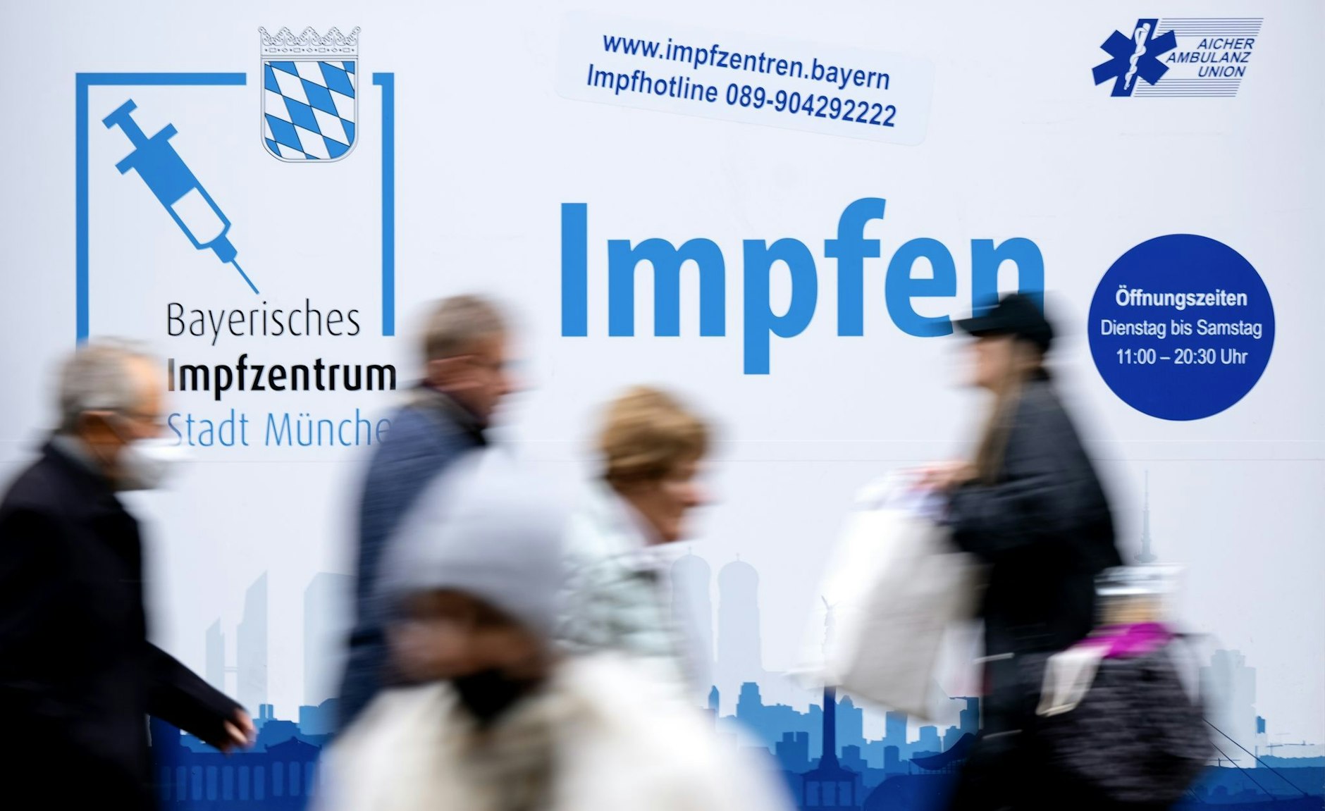 Passanten gehen an einem Impfzentrum in der Münchener Innenstadt vorbei.  