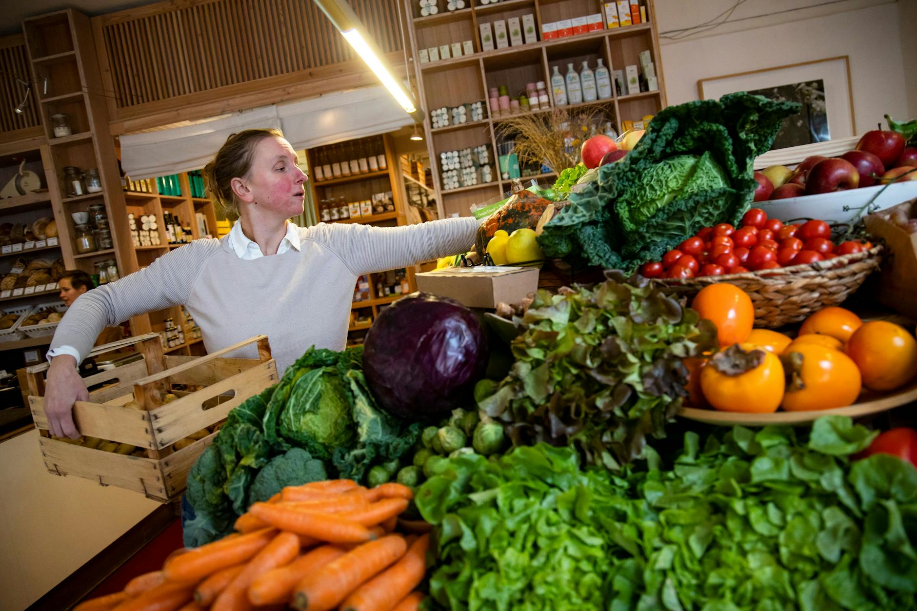 Inhaberin Martina Marggraf sortiert Gemüse und Obst in ihrem Bioladen in Berlin-Wedding.