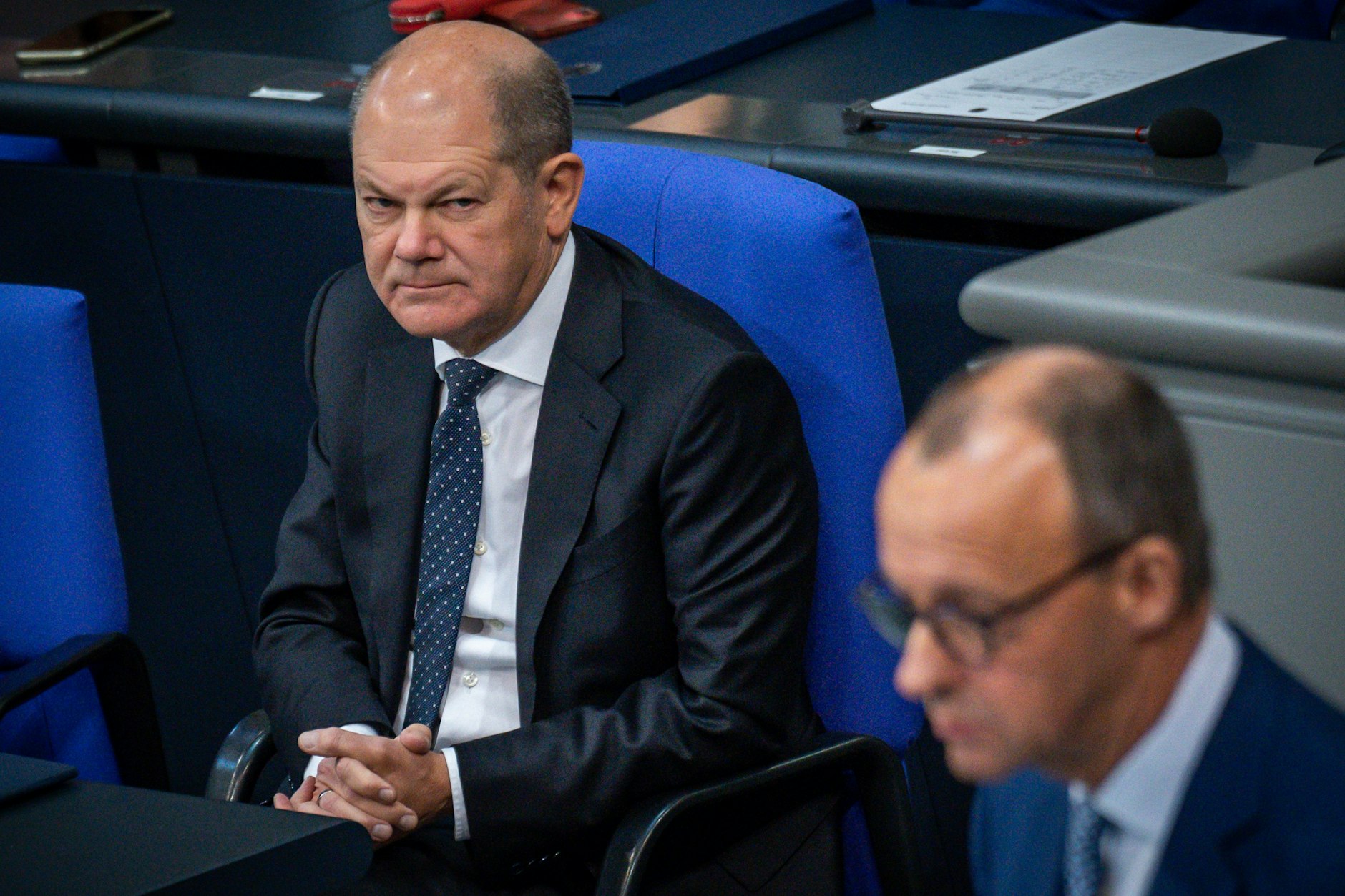 Bundeskanzler Olaf Scholz (SPD) beobachtet Friedrich Merz, CDU-Bundesvorsitzender, im Bundestag in der Generaldebatte der Haushaltswoche.