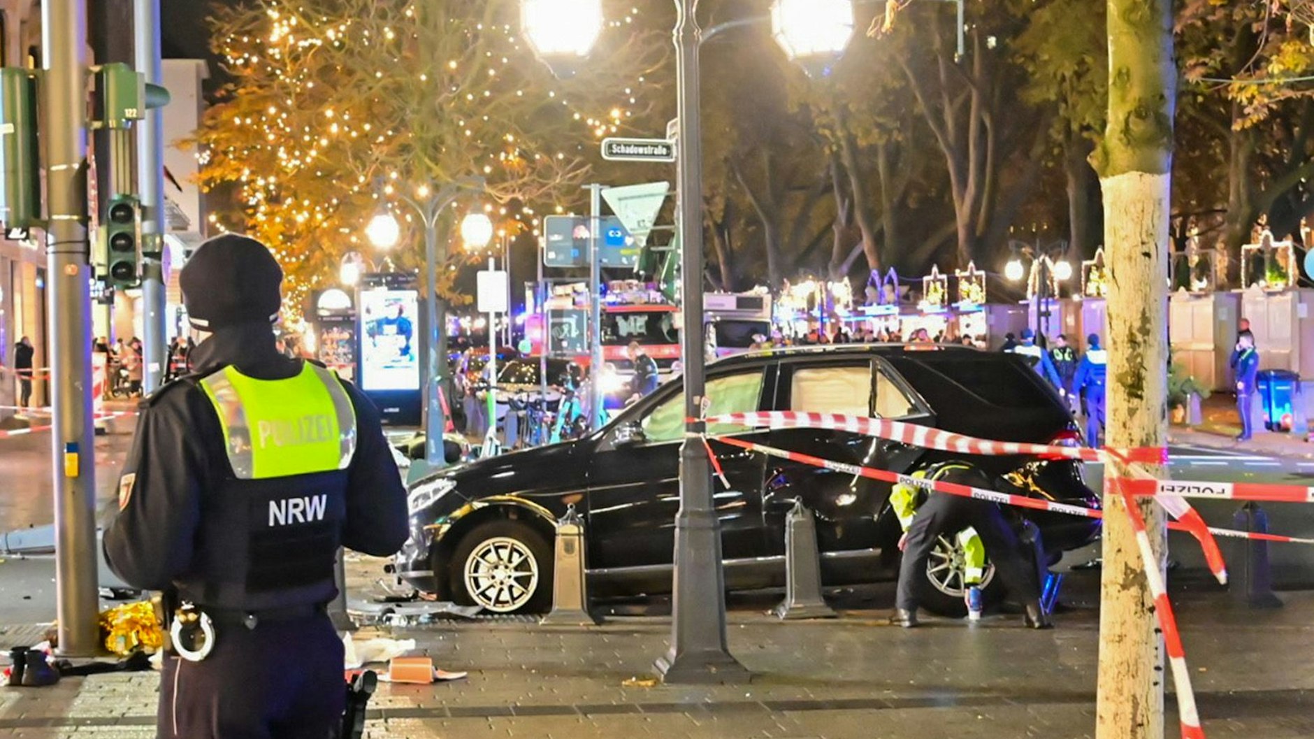 Flatterband sichert die Unfallstelle rund um ein Auto auf der Königsallee.  Ein 84-Jähriger habe am frühen Dienstagabend die Kontrolle über sein Auto verloren und sei dann in parkende E-Scooter gefahren.