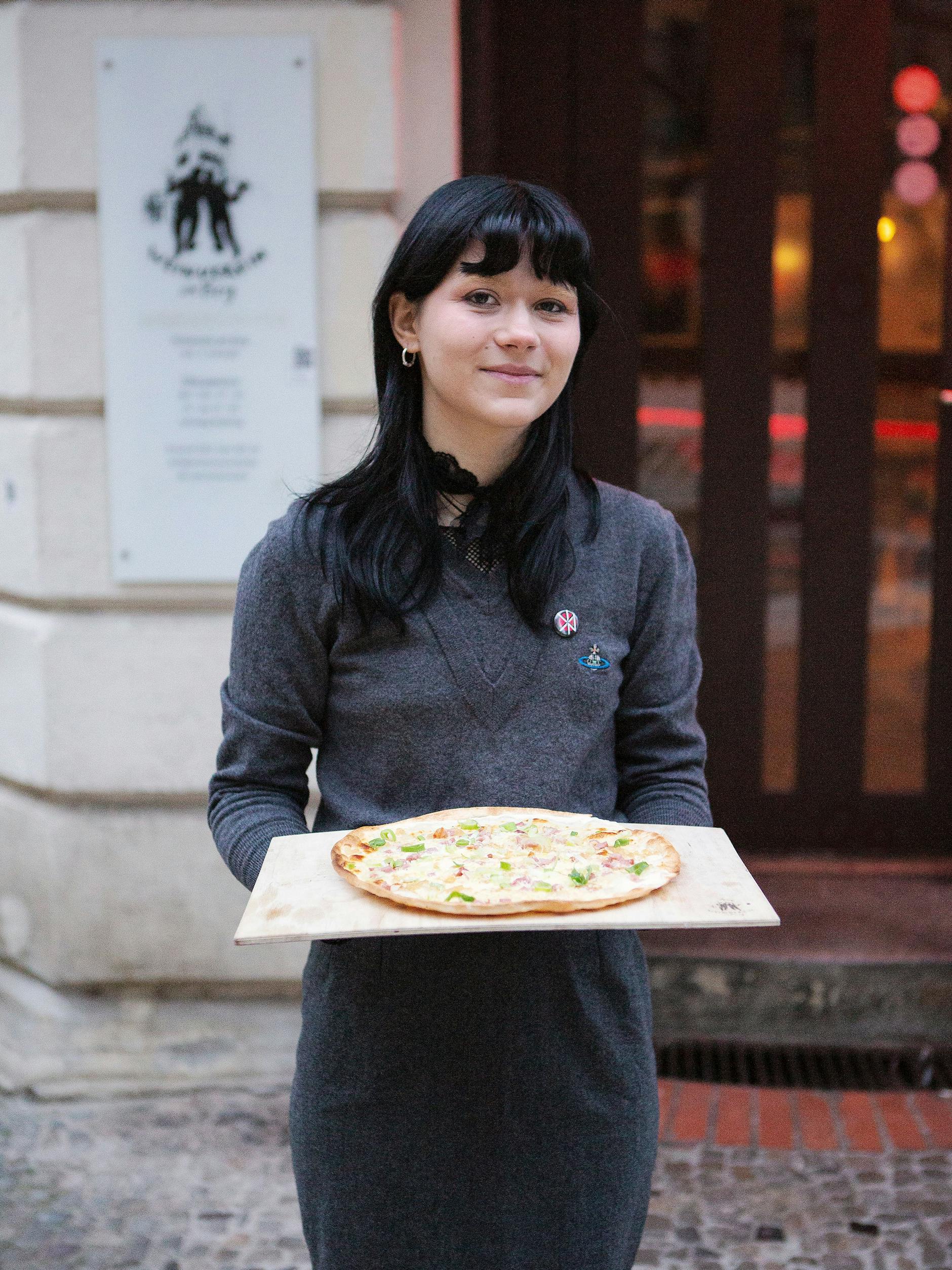 Kellnerin Selma vom Weinverein Kreuzberg serviert Flammkuchen.