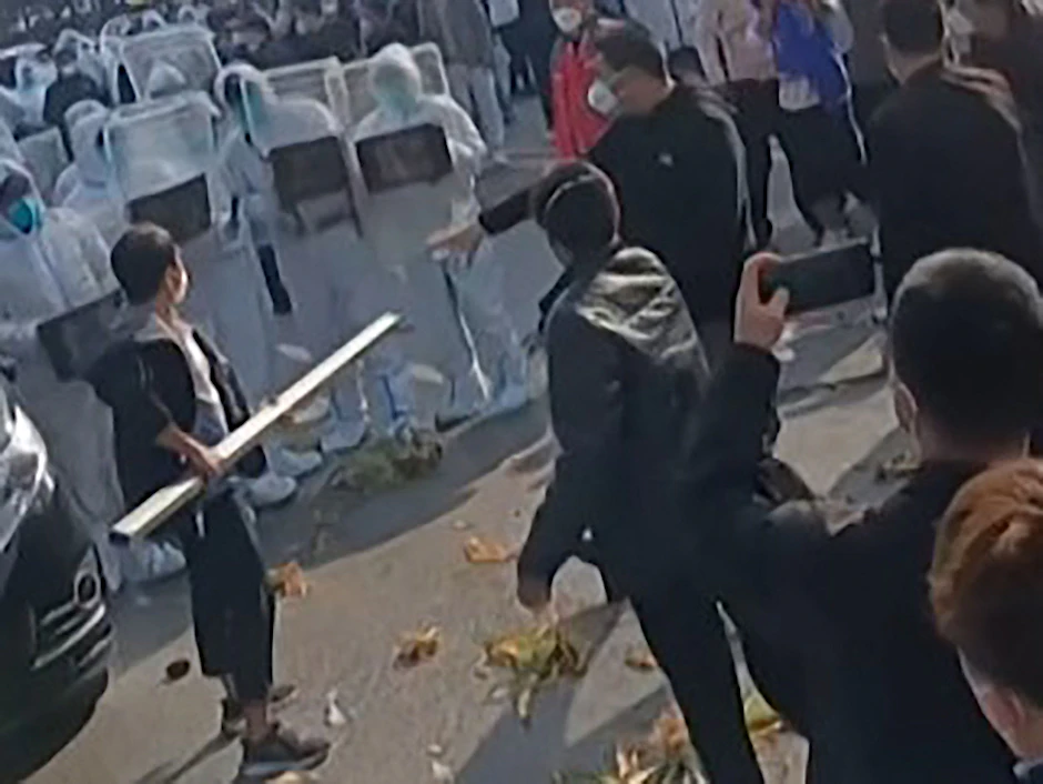 Dieses Bild aus einem AFP-Video vom 23. November 2022 zeigt, wie Arbeiter in der iPhone-Fabrik von Foxconn in Zhengzhou in Zentralchina mit der Polizei zusammenstoßen.