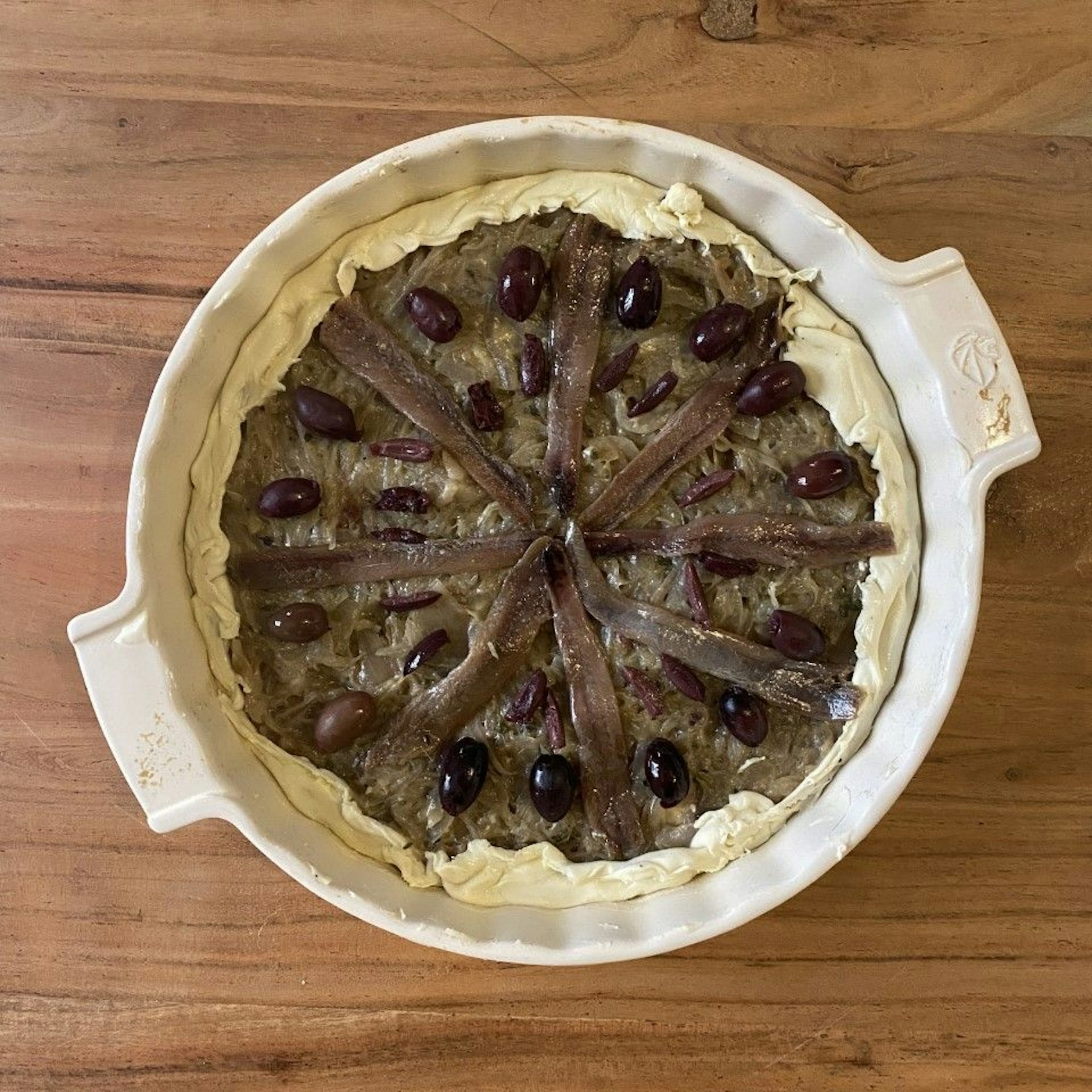 Schön belegt und jetzt ab in den Ofen: Pissaladière.