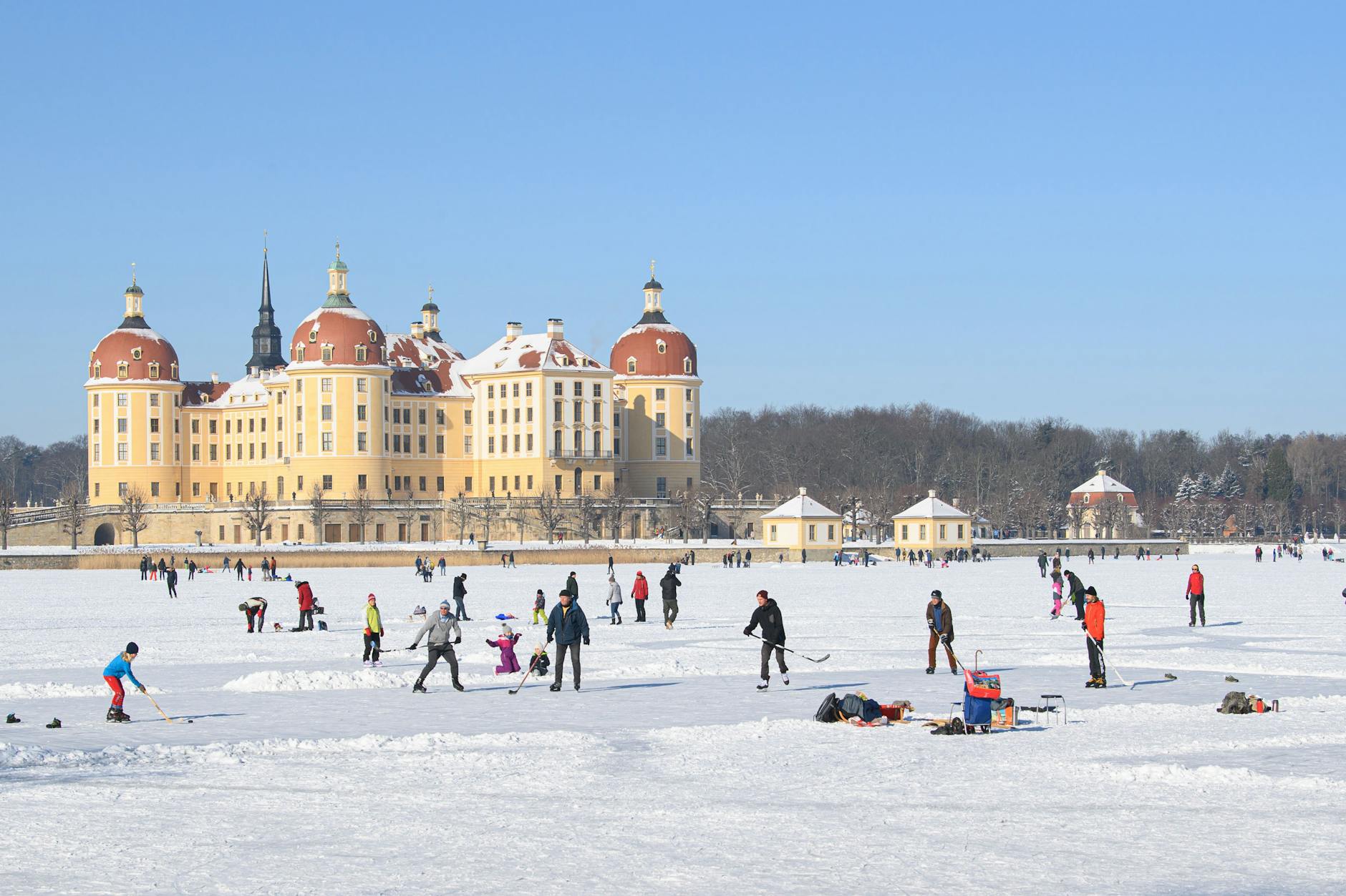 Auf Schlittschuhen auf dem zugefrorenen Schlossteich vor dem Schloss Moritzburg, einem einstigen Jagdschloss der Wettiner 