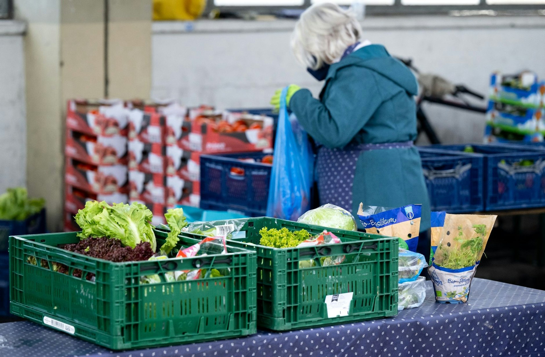 Ehrenamtliche Helfer der Münchner Tafel sortieren an der Ausgabestelle am Großmarkt in München Lebensmittel für die Gäste.