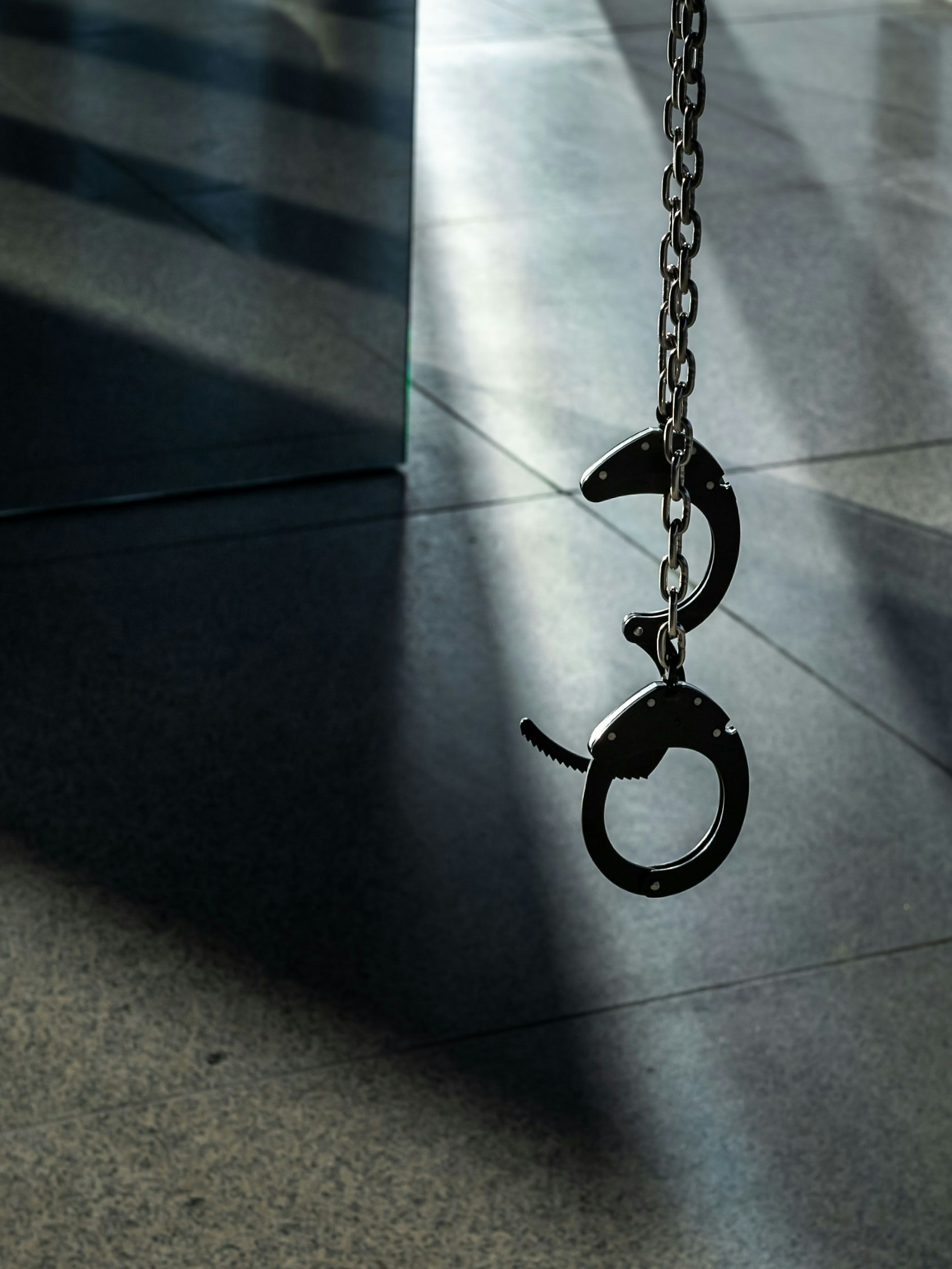 Handschellen zur Publikumsbenutzung baumeln von der Museumsdecke.