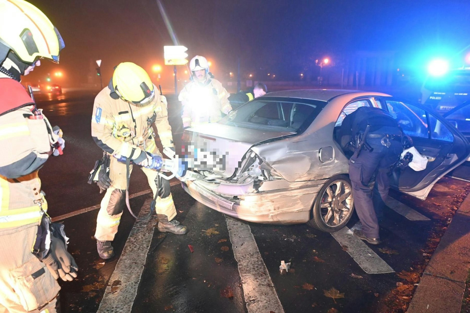 Feuerwehrleute und Polizisten untersuchen ein Fluchtauto, das Schlangenlinien fuhr.